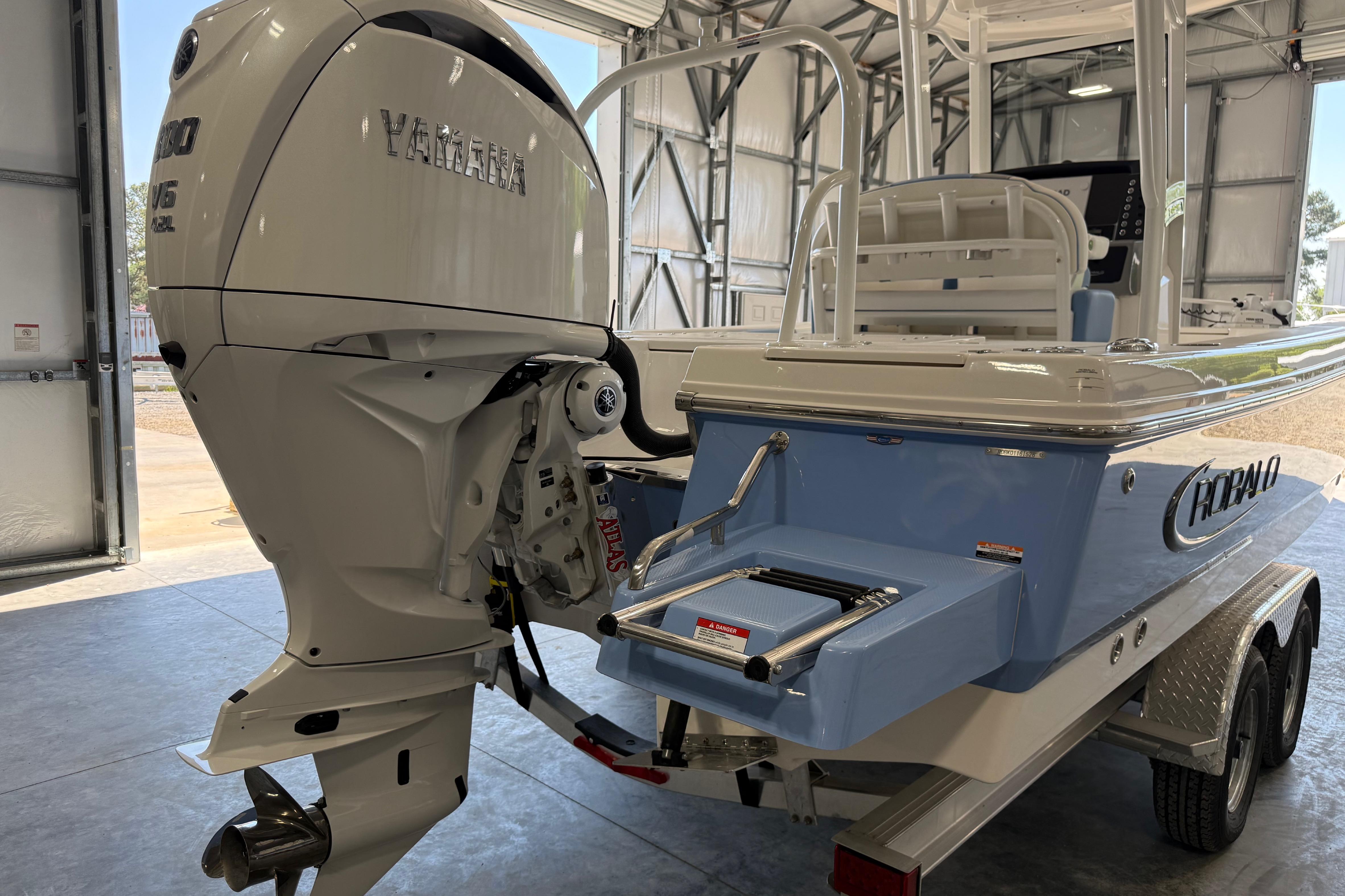 2026 Robalo 246 Cayman boat with Yamaha engine in a garage setting.