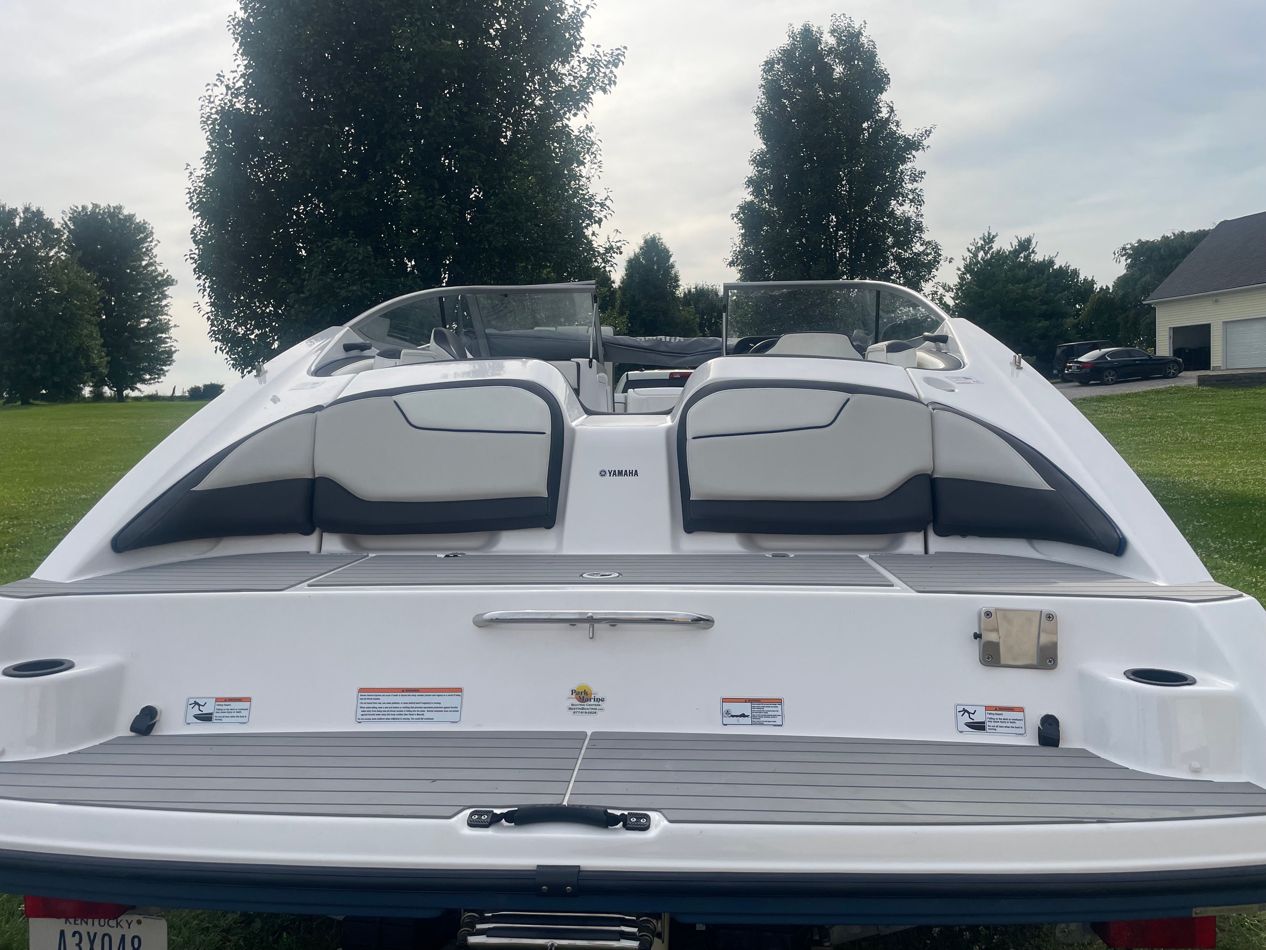 The image shows the rear of a 2019 Yamaha SX210 boat on a lawn.