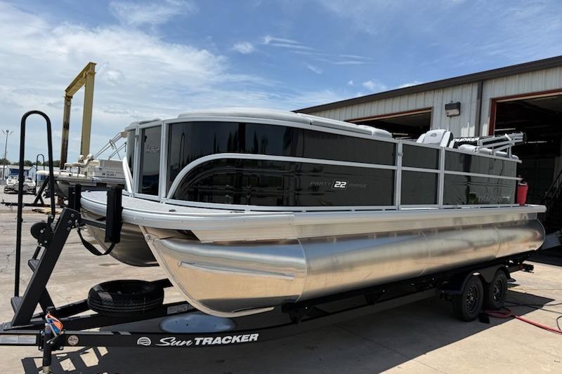 2026 Sun Tracker Party Barge 22 XP3 pontoon boat on trailer, parked outdoors.