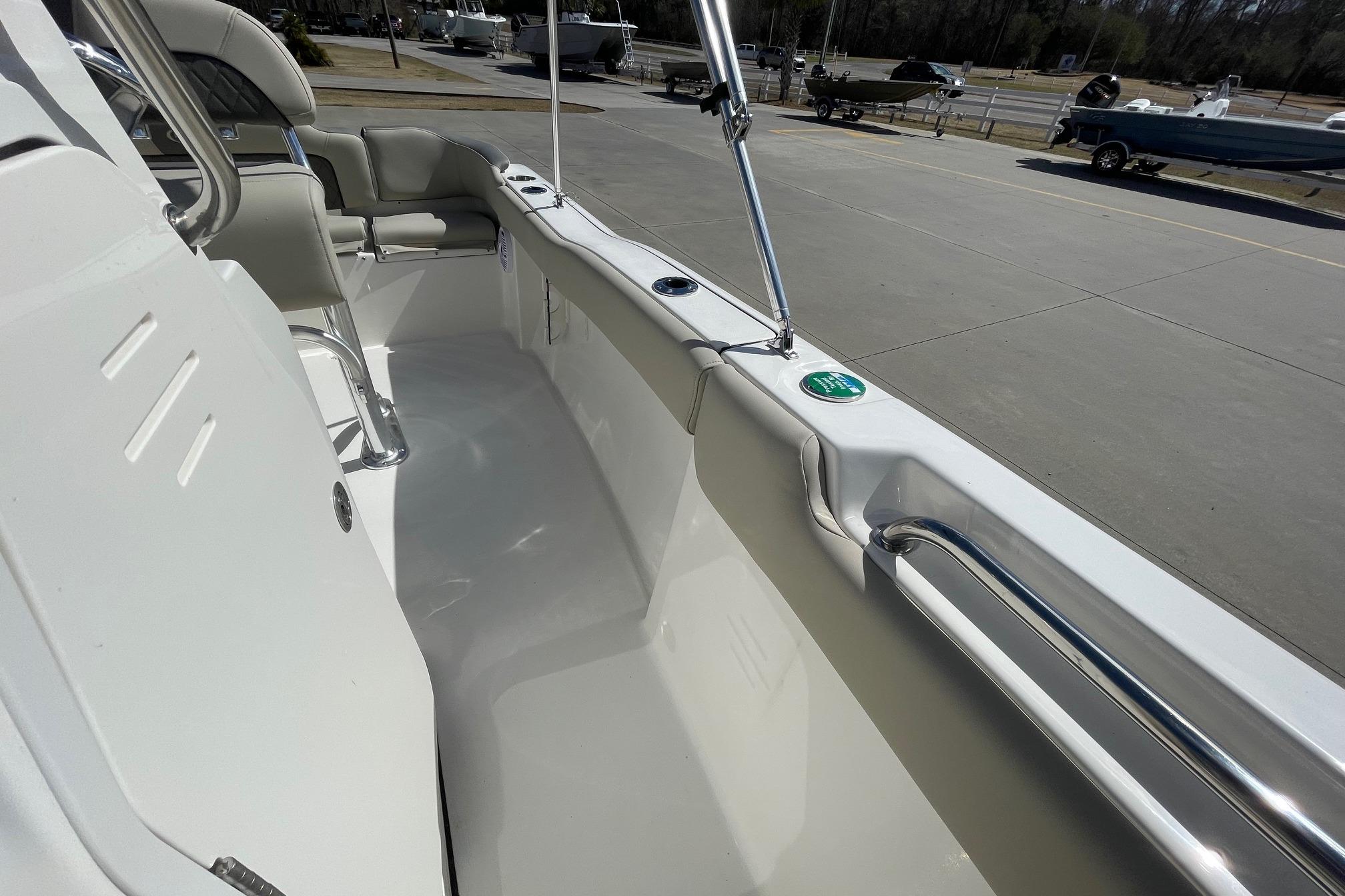 2026 Key West 203 FS boat interior with seating and railing, parked on concrete.