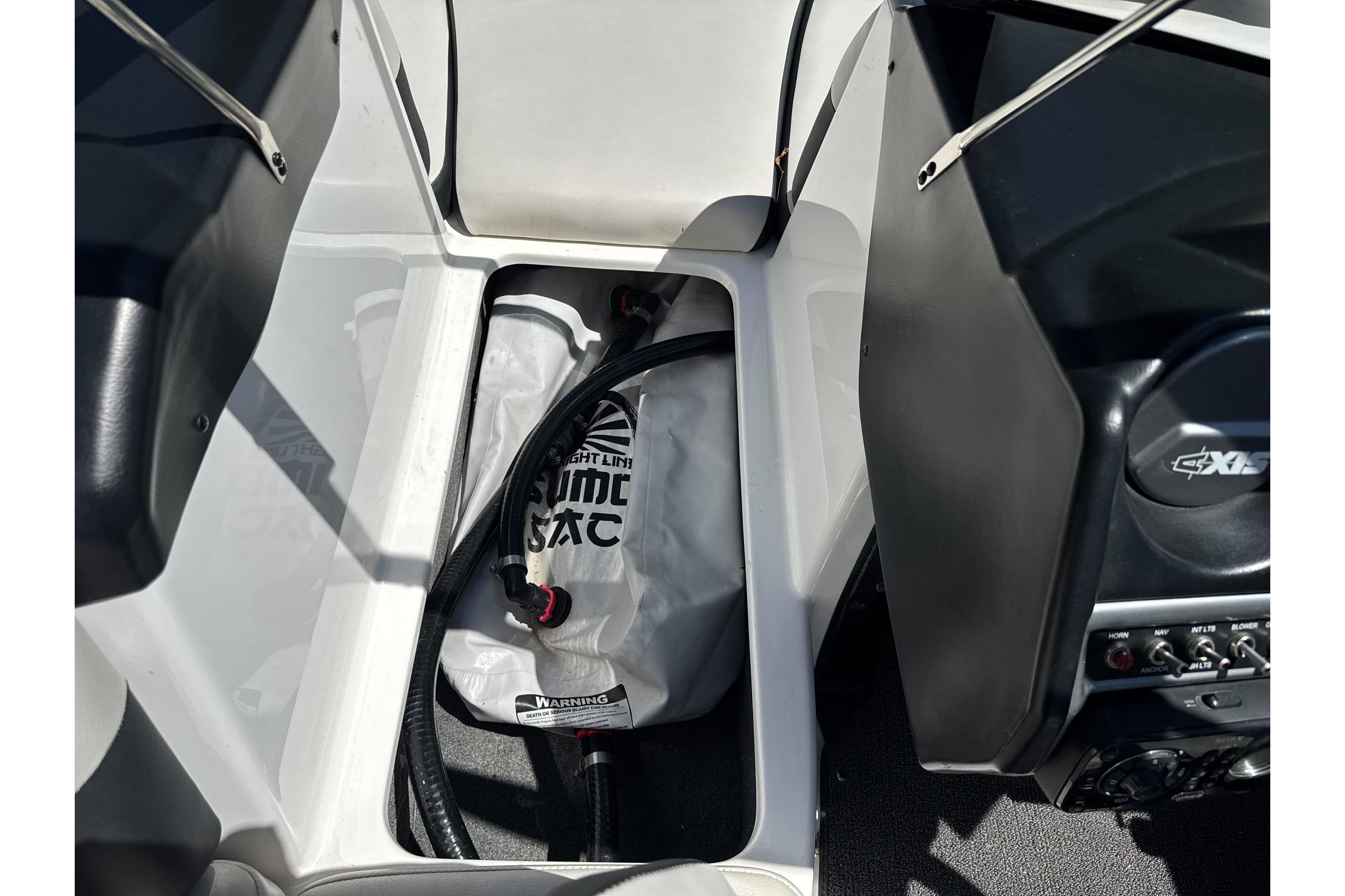 2015 Axis A20 boat interior storage compartment with ballast bag and hose.
