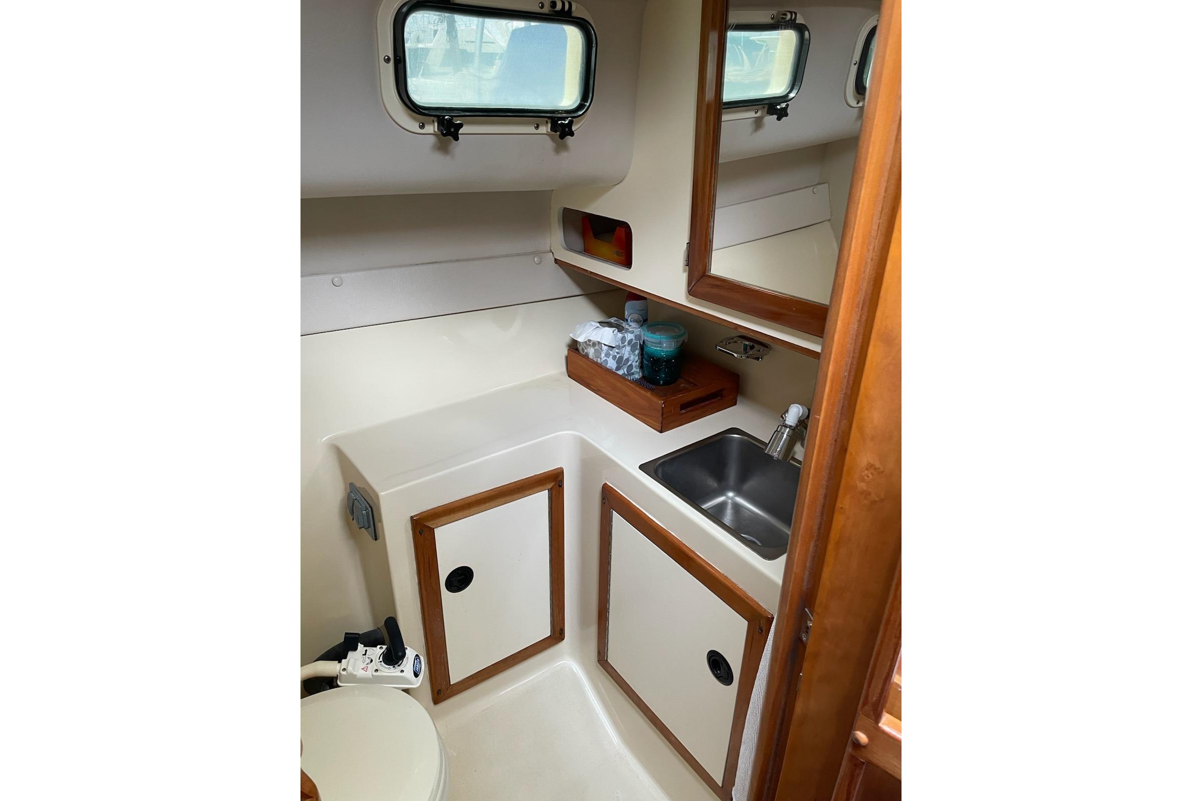 2003 Albin 28 Tournament Express boat interior with sink, storage, and window.