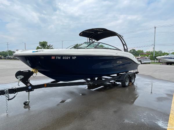 2023 Sea Ray SPX 230 boat on trailer, parked outdoors under cloudy sky.
