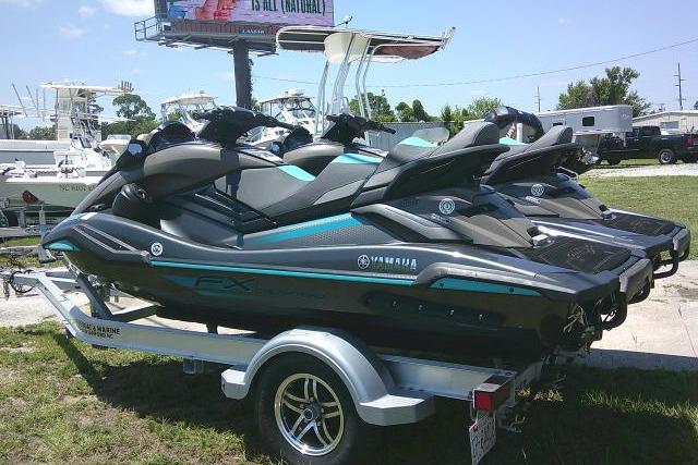 2023 Yamaha FX Cruiser HO jet skis on a trailer, parked outdoors.