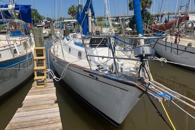 1979 Pearson 365 Ketch sailboat docked at marina with wooden walkway.