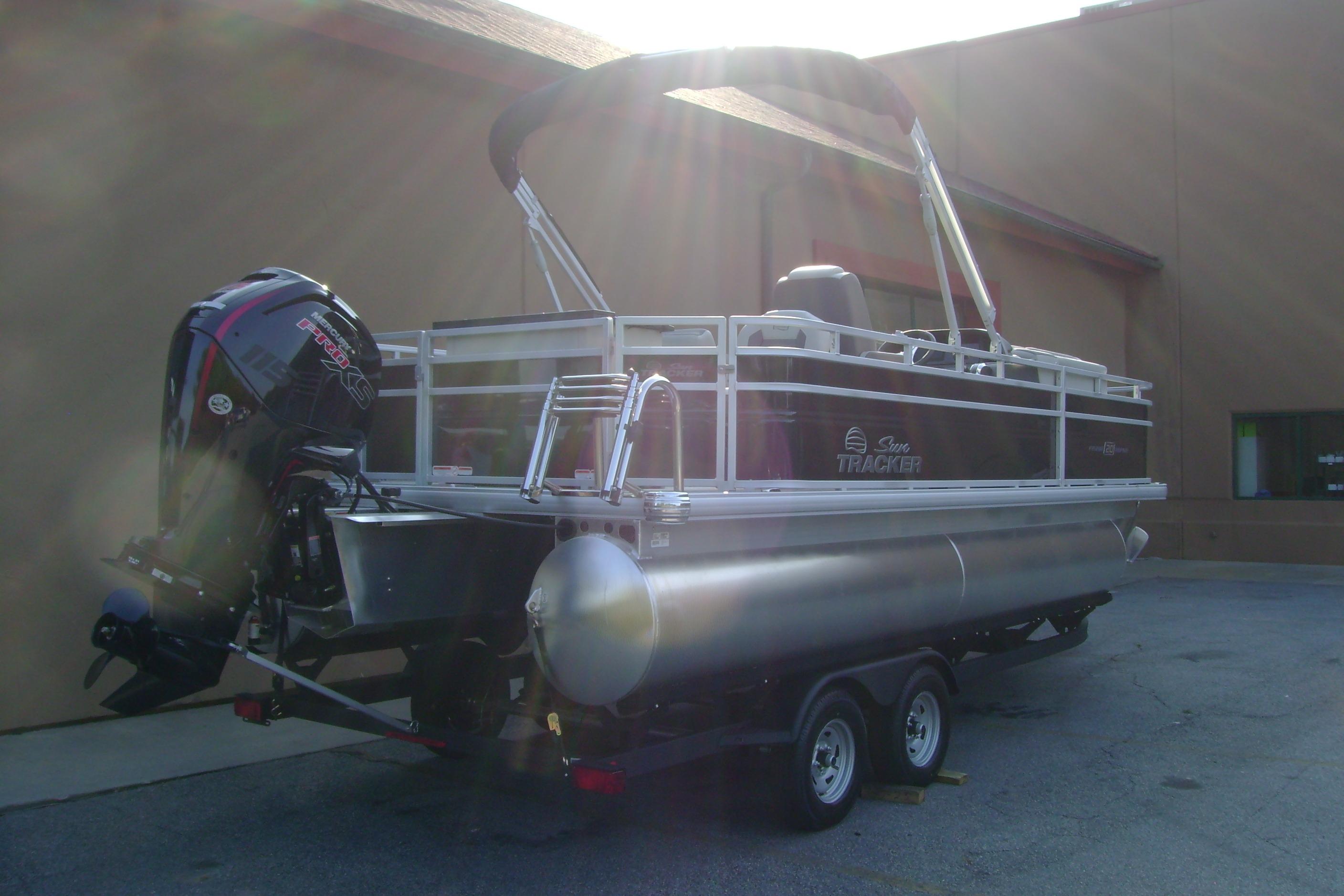 2026 Sun Tracker Fishin' Barge 20 DLX pontoon boat with outboard motor on trailer.
