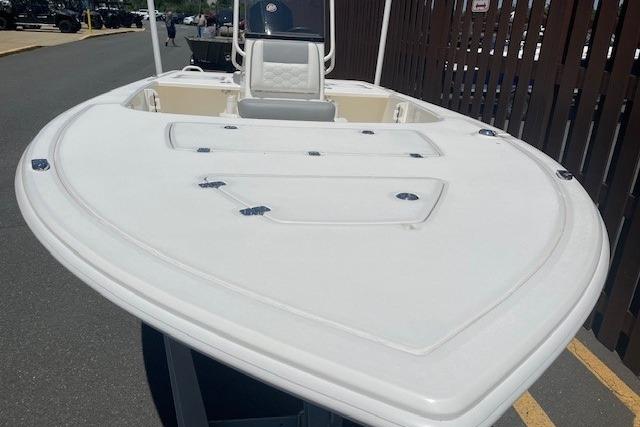 2026 Mako 18 Pro Skiff boat with spacious deck and seating, parked outdoors.
