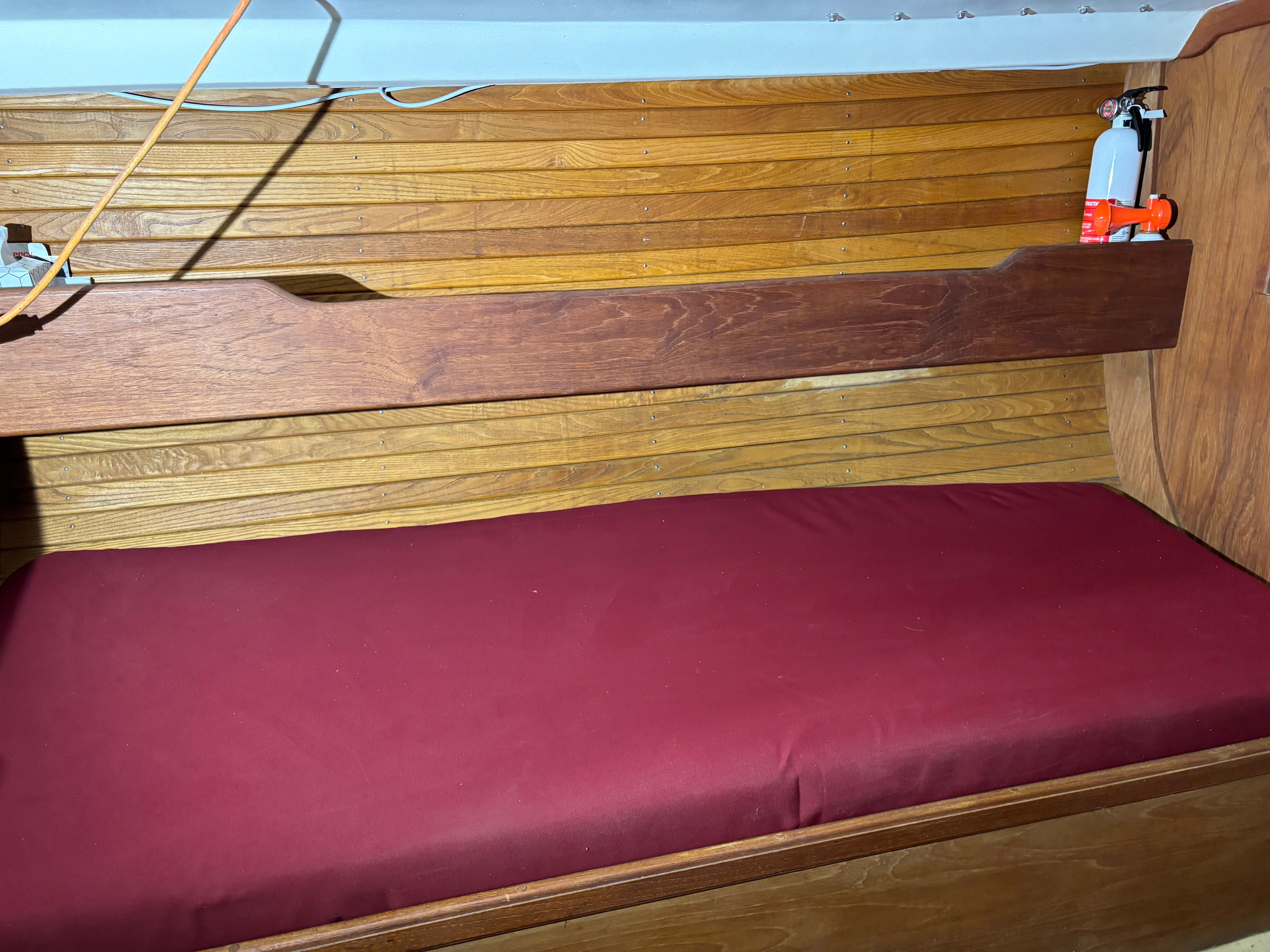 Interior of a Cape Dory 26 yacht with red cushion.