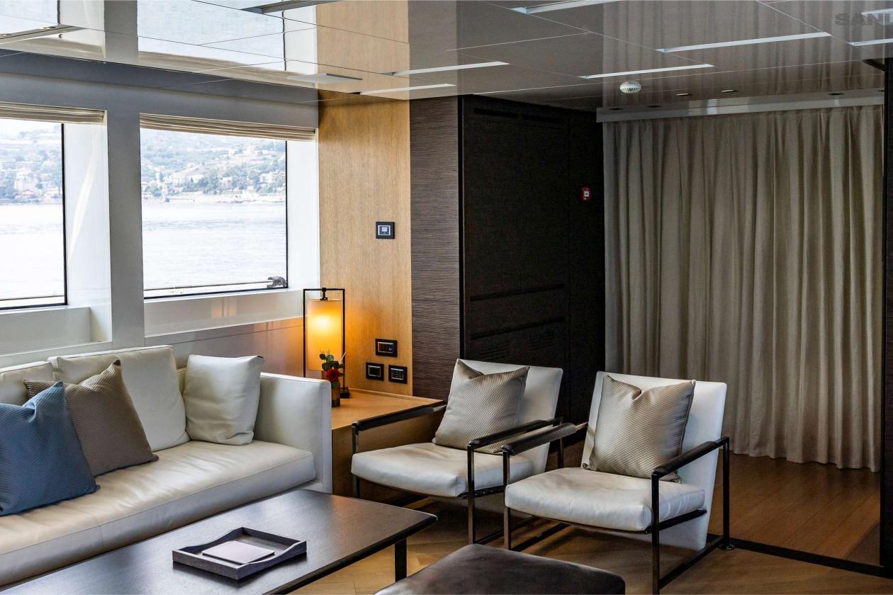 Luxurious interior of 2016 Sanlorenzo SL96 yacht with modern seating and scenic window view.