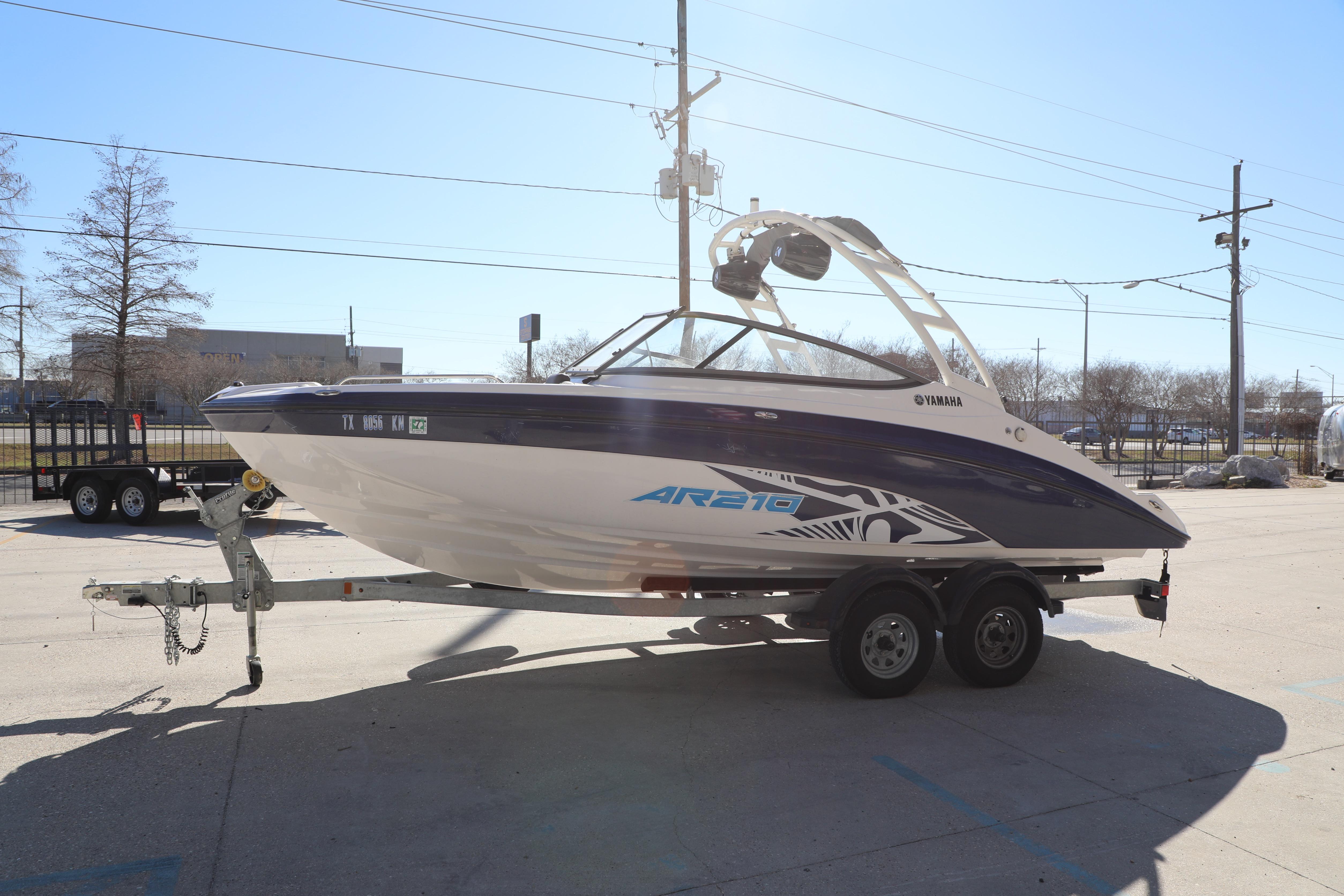2022 Yamaha AR210 boat on trailer, parked outdoors in a sunny setting.