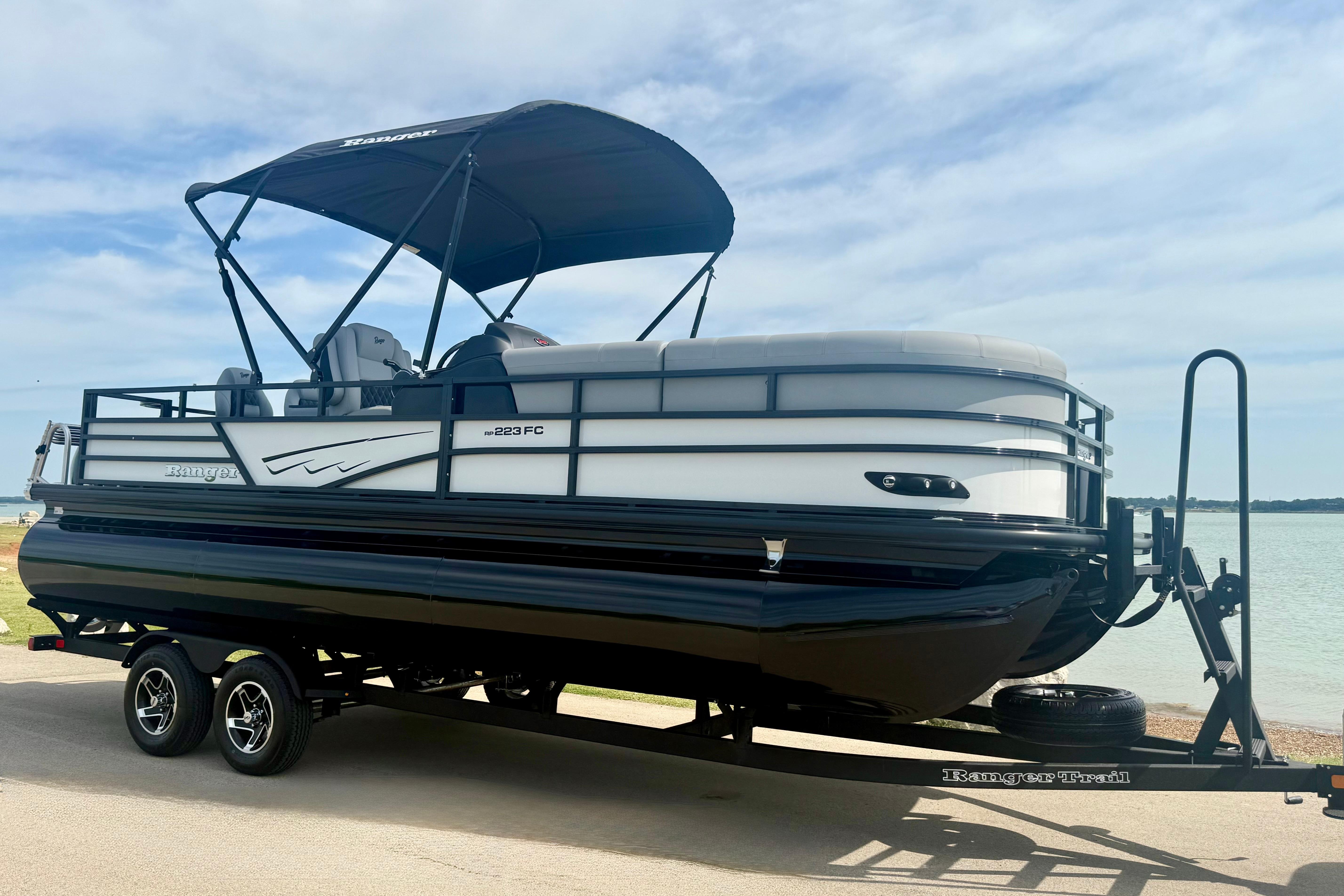 2026 Ranger 223FC pontoon boat on trailer by a lake.