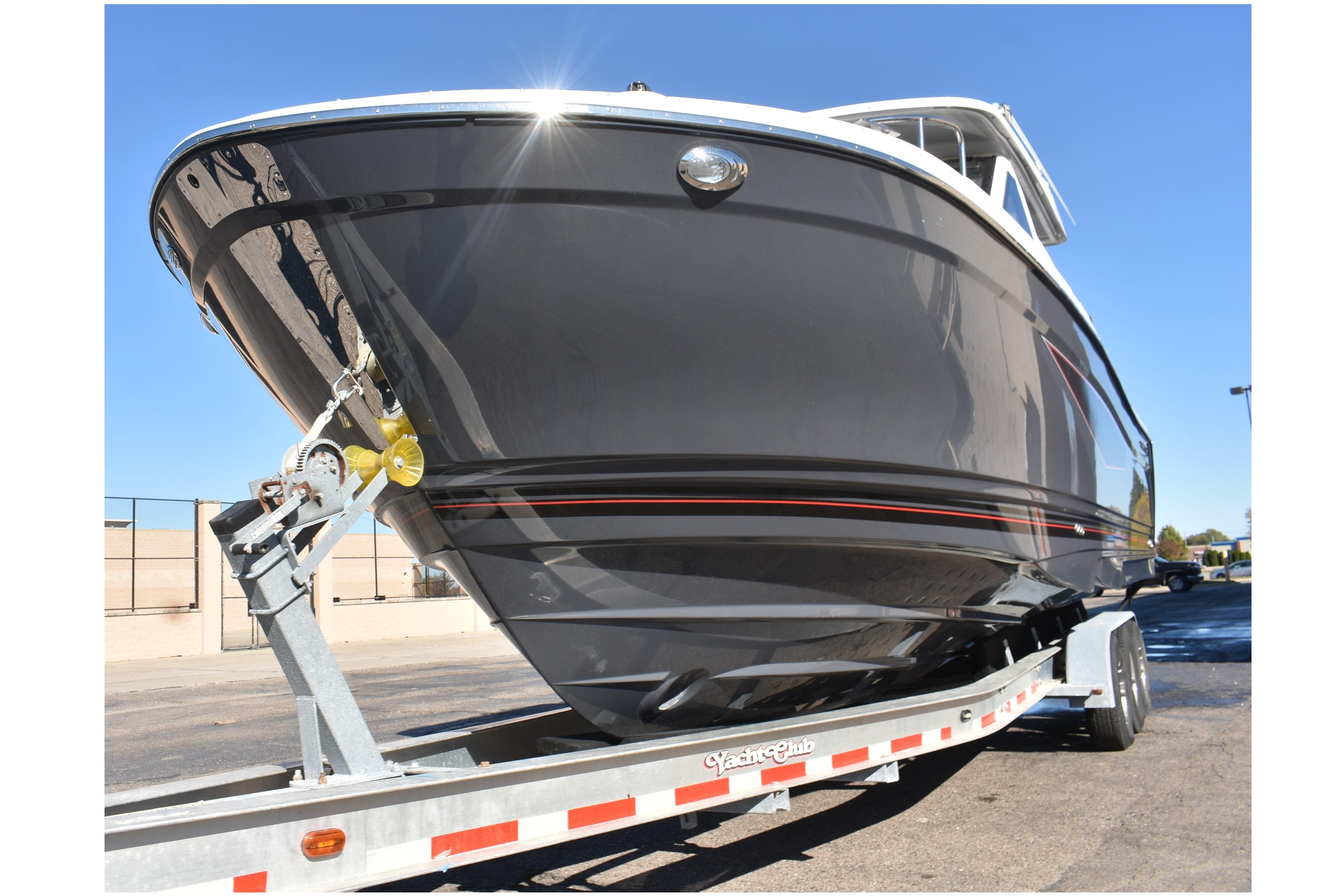 2025 Solara S-310 CW boat on trailer, sleek black hull, outdoor setting.