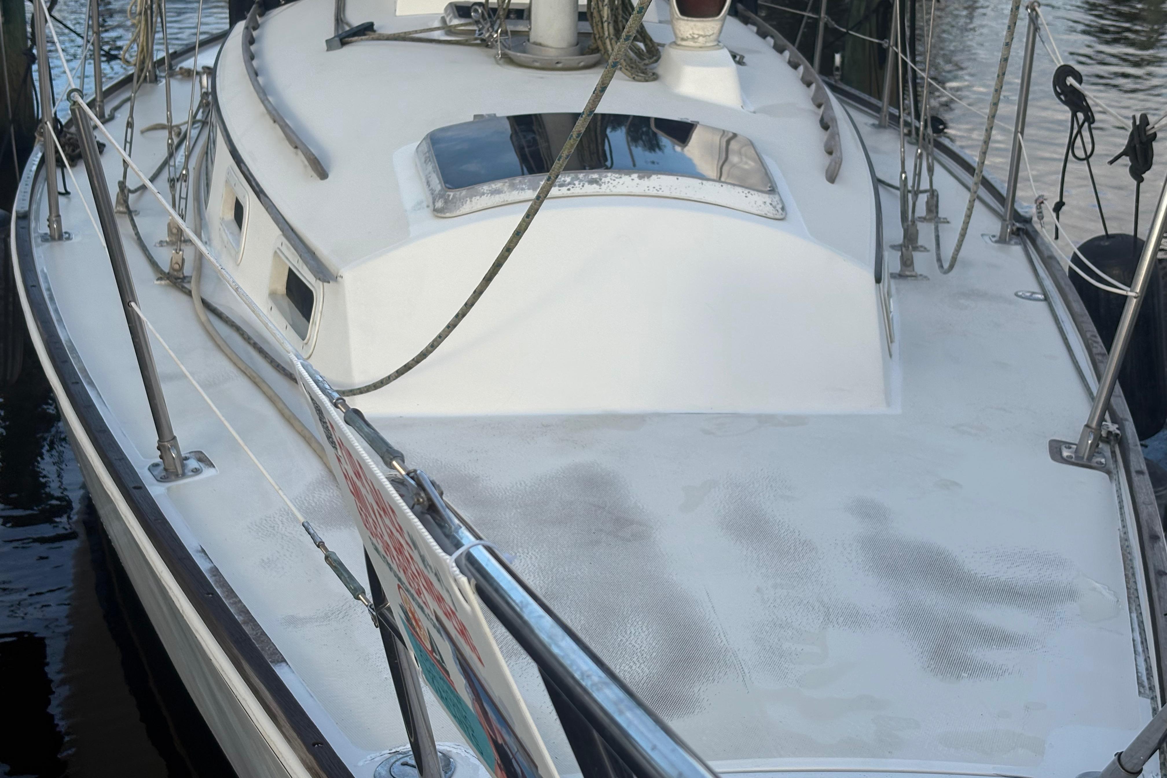 1981 Sabre 31 sailboat deck with railing and hatch, docked by the water.
