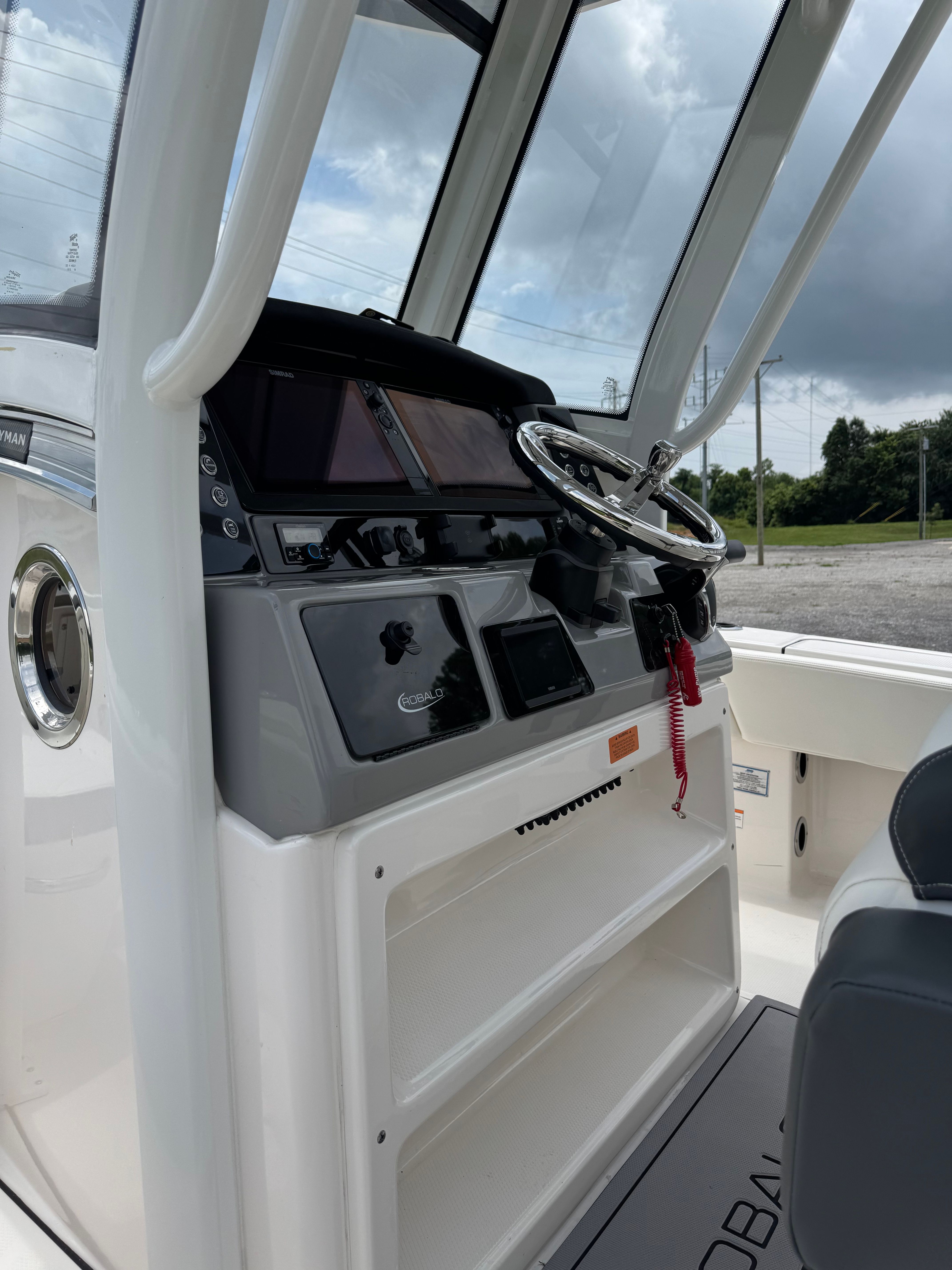 The image shows the helm of a 2023 Robalo 266 Cayman boat with modern instruments.