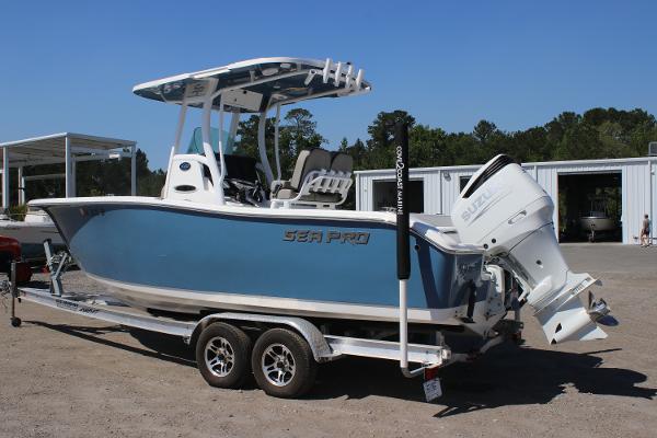 2023 Sea Pro 239 Center Console boat on trailer, blue hull, parked outdoors.