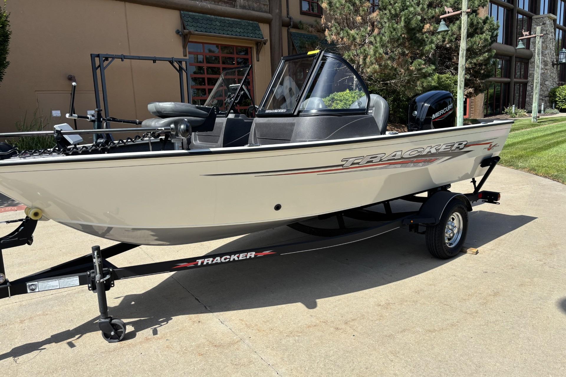 2022 Tracker Pro Guide V-16 SC boat on trailer, parked outdoors.