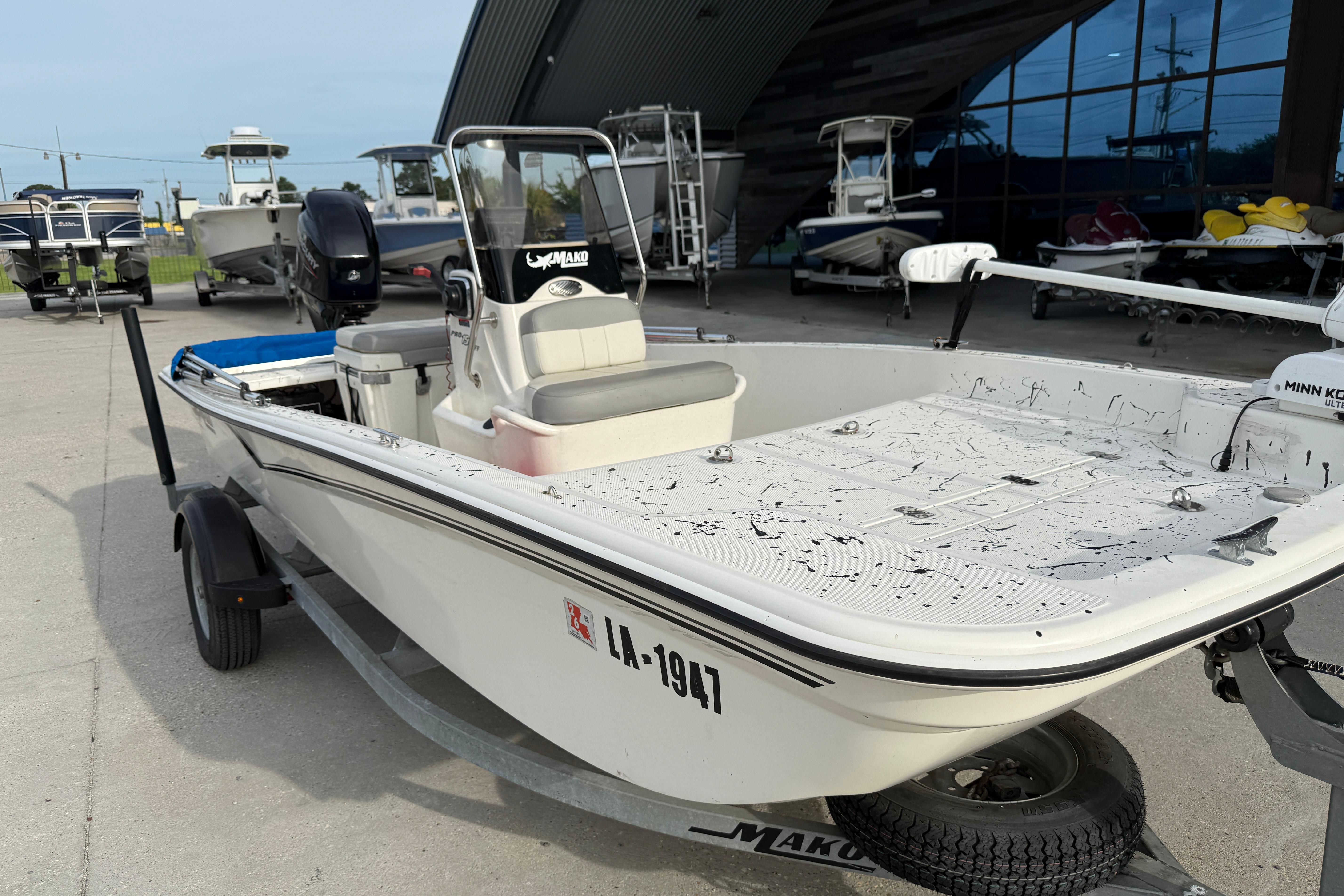 2020 Mako Pro Skiff 15 CC boat on trailer, parked outdoors near other boats.