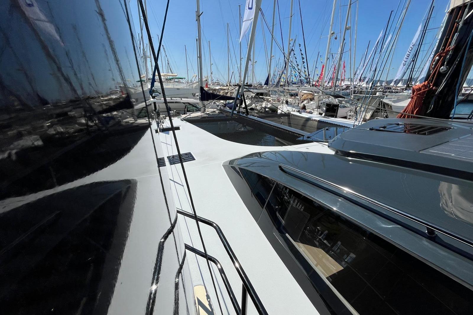 2026 Comar C-CAT 65 catamaran docked among other sailboats at a marina.
