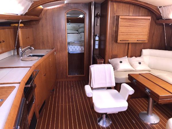 Interior of 2001 Jeanneau 45.2 yacht with wood finish and comfortable seating.