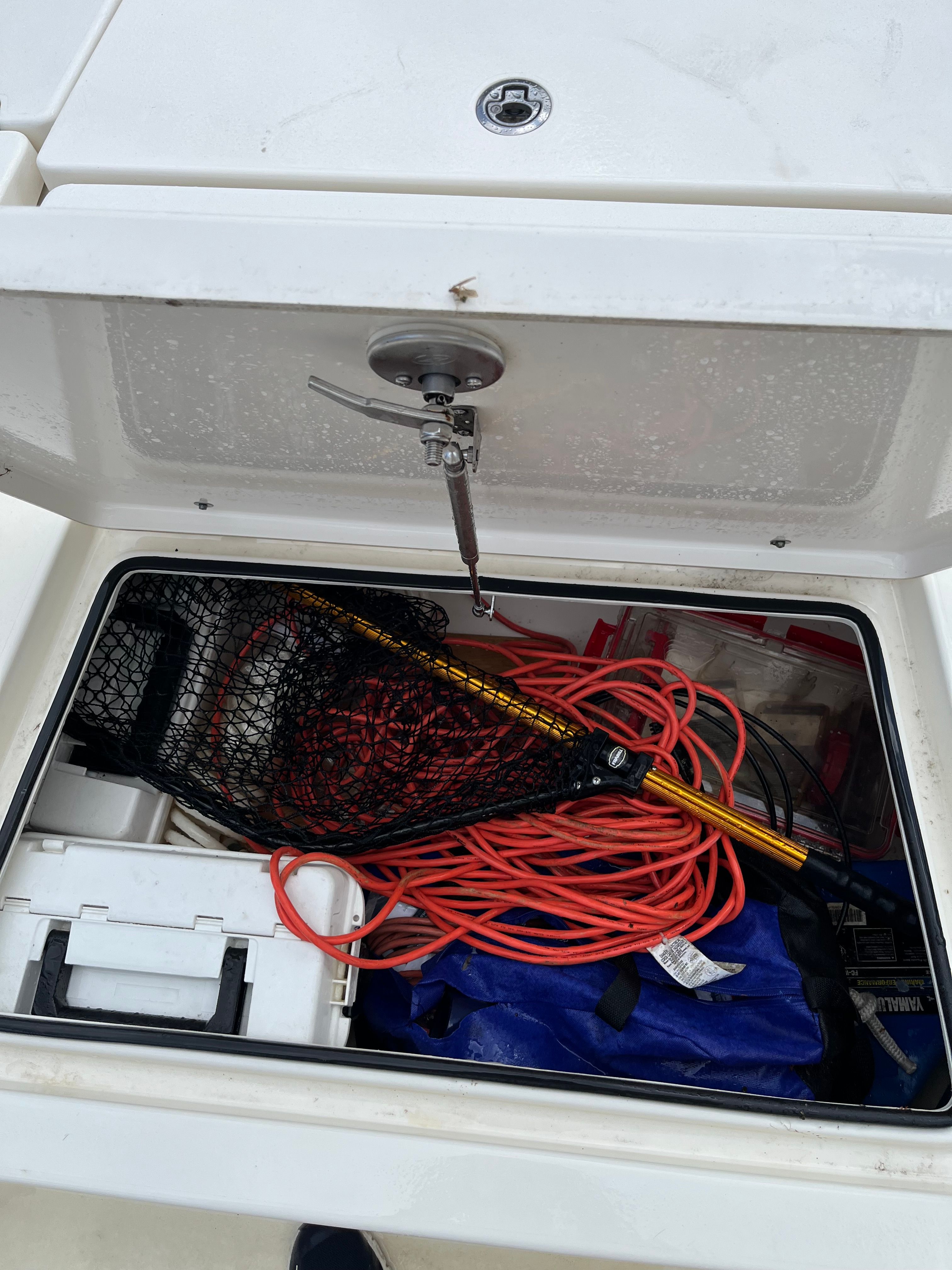 Storage compartment of a Pathfinder 2400 TRS boat with fishing gear.