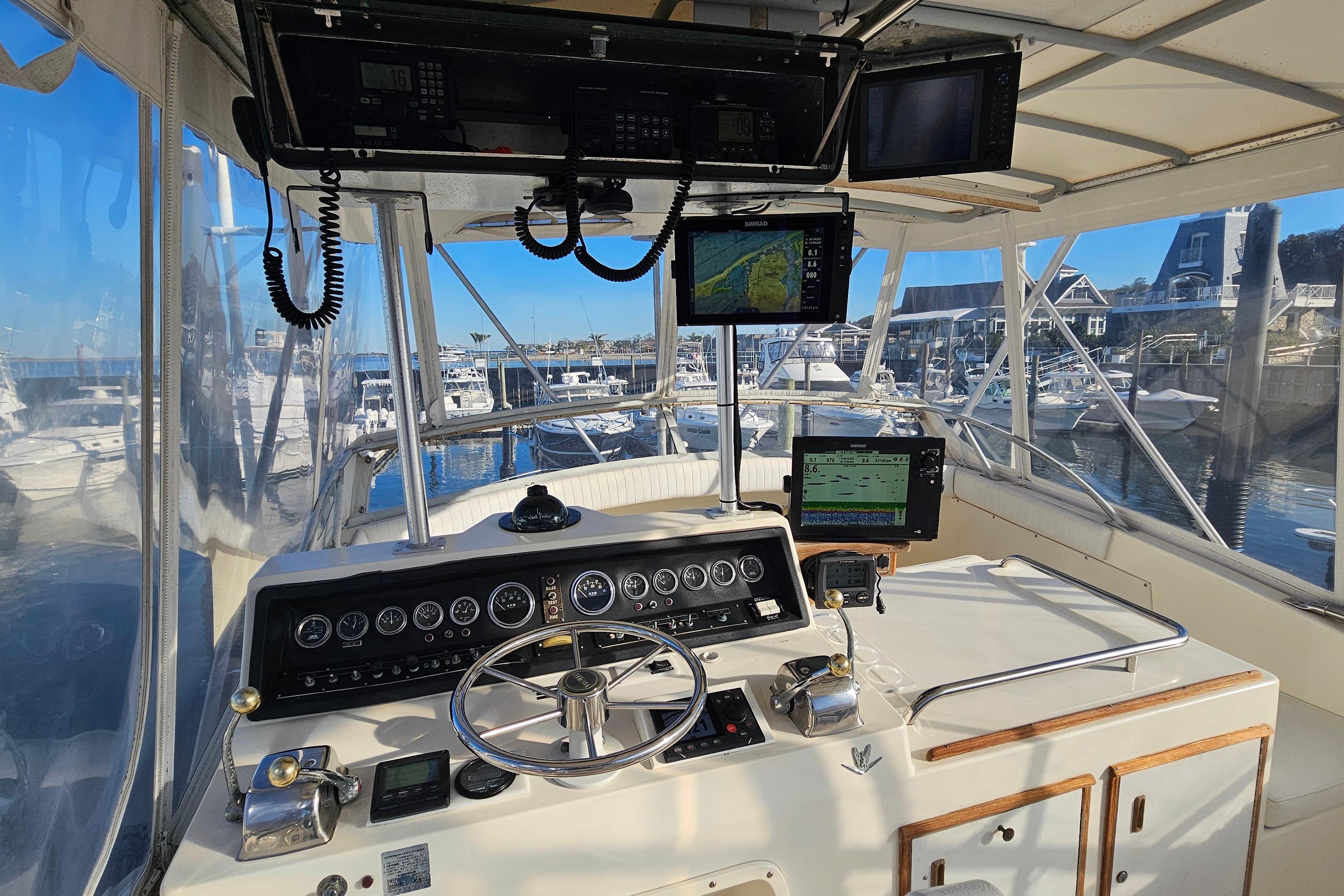 Cockpit view of a 1980 Bertram 42 Convertible yacht at a marina.