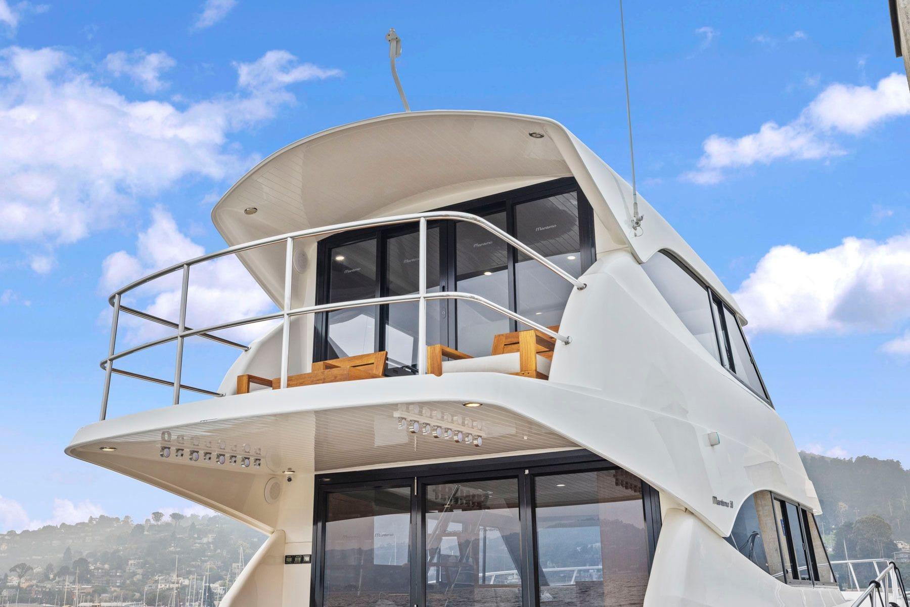 2014 Maritimo M50 yacht with sleek design and upper deck, set against a blue sky.