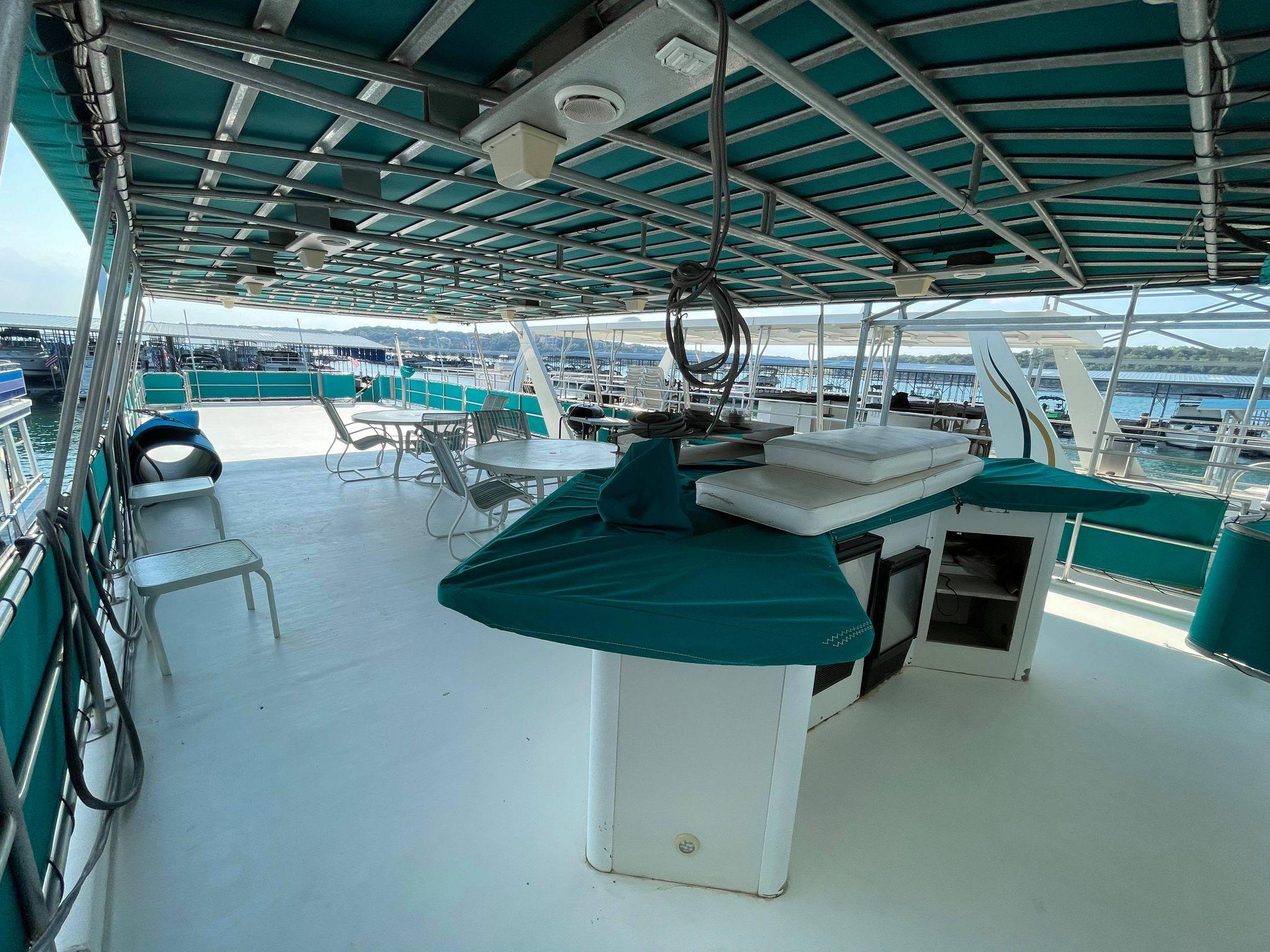 1998 Sumerset 86' by 18' houseboat upper deck with covered seating and bar area.