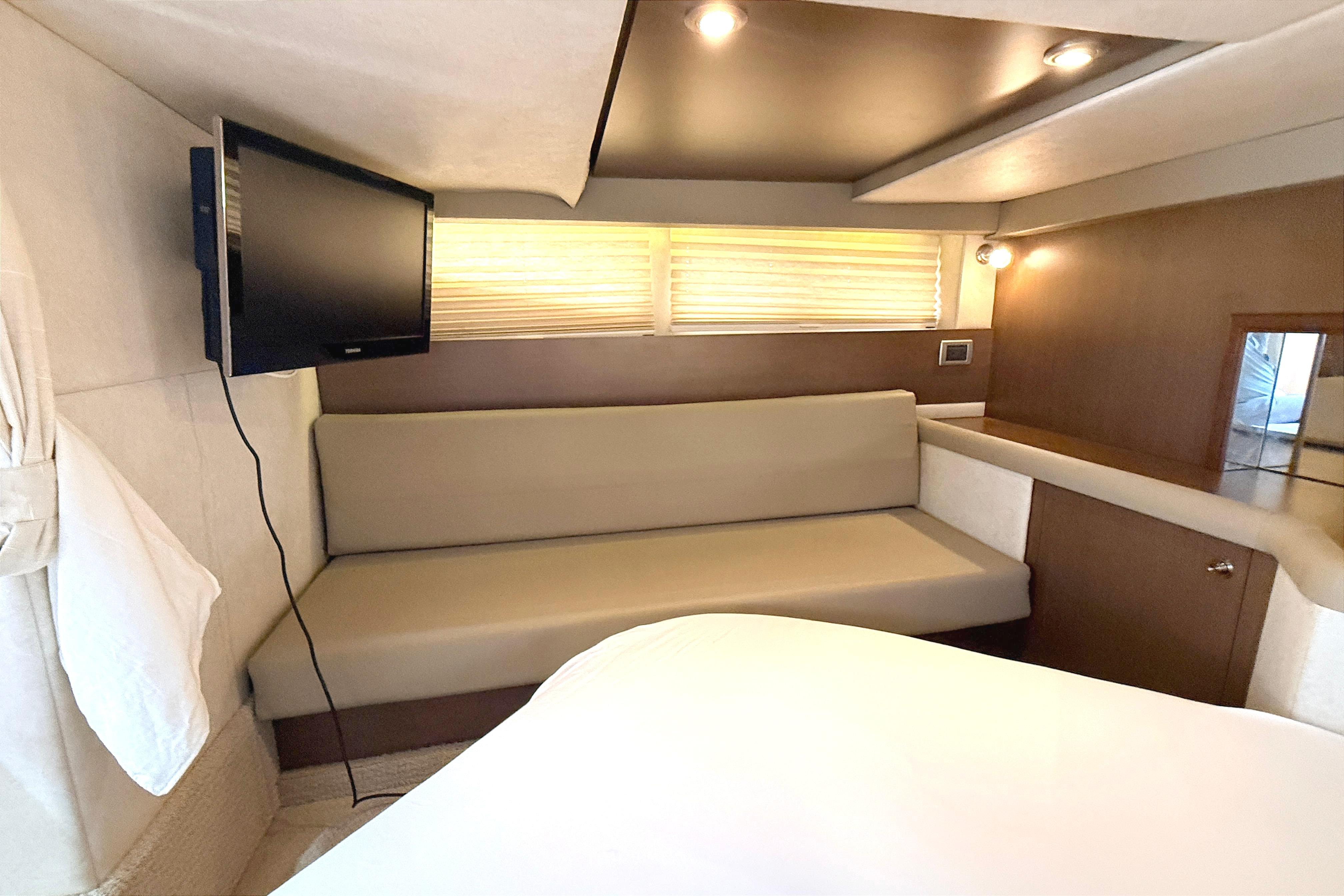 Interior of 2013 Sea Ray 370 Venture yacht with sofa, TV, and modern lighting.