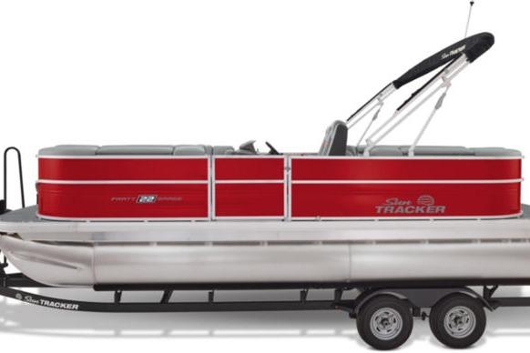 2026 Sun Tracker Party Barge 22 DLX pontoon boat with red and silver design on trailer.