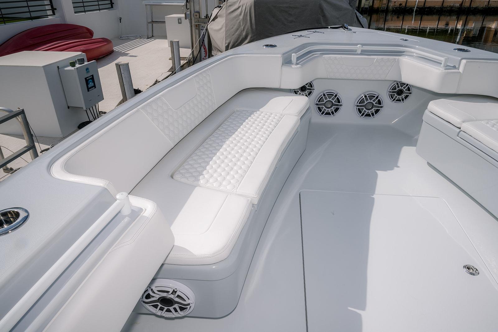 Luxurious seating area on 2024 Contender 44 ST boat with white upholstery and speakers.