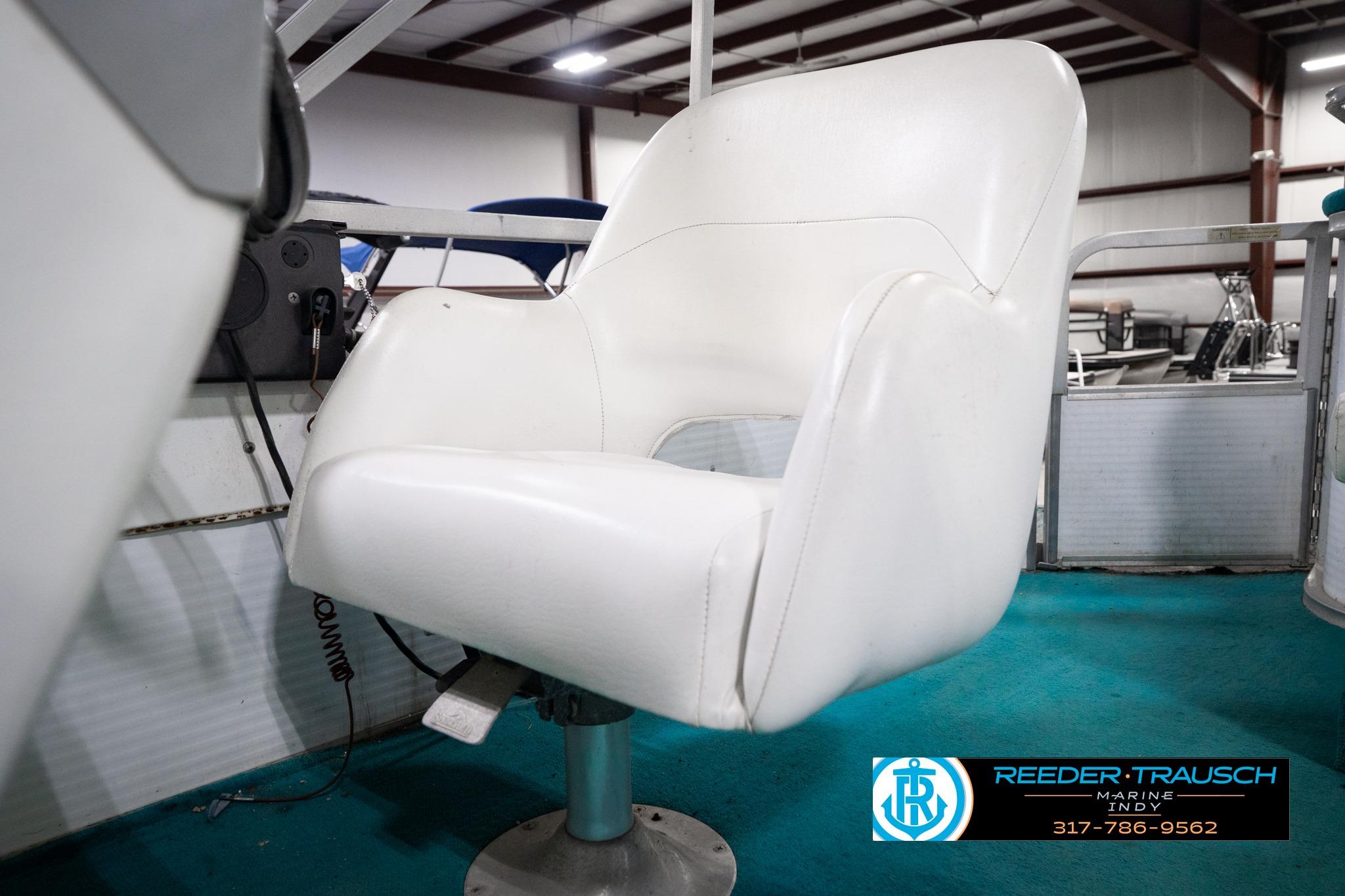 White captain's chair on a 1992 Godfrey Sweetwater boat, with teal carpet and visible controls.