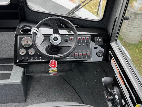 2024 Spartan 220 Maximus boat dashboard with steering wheel and control panel.