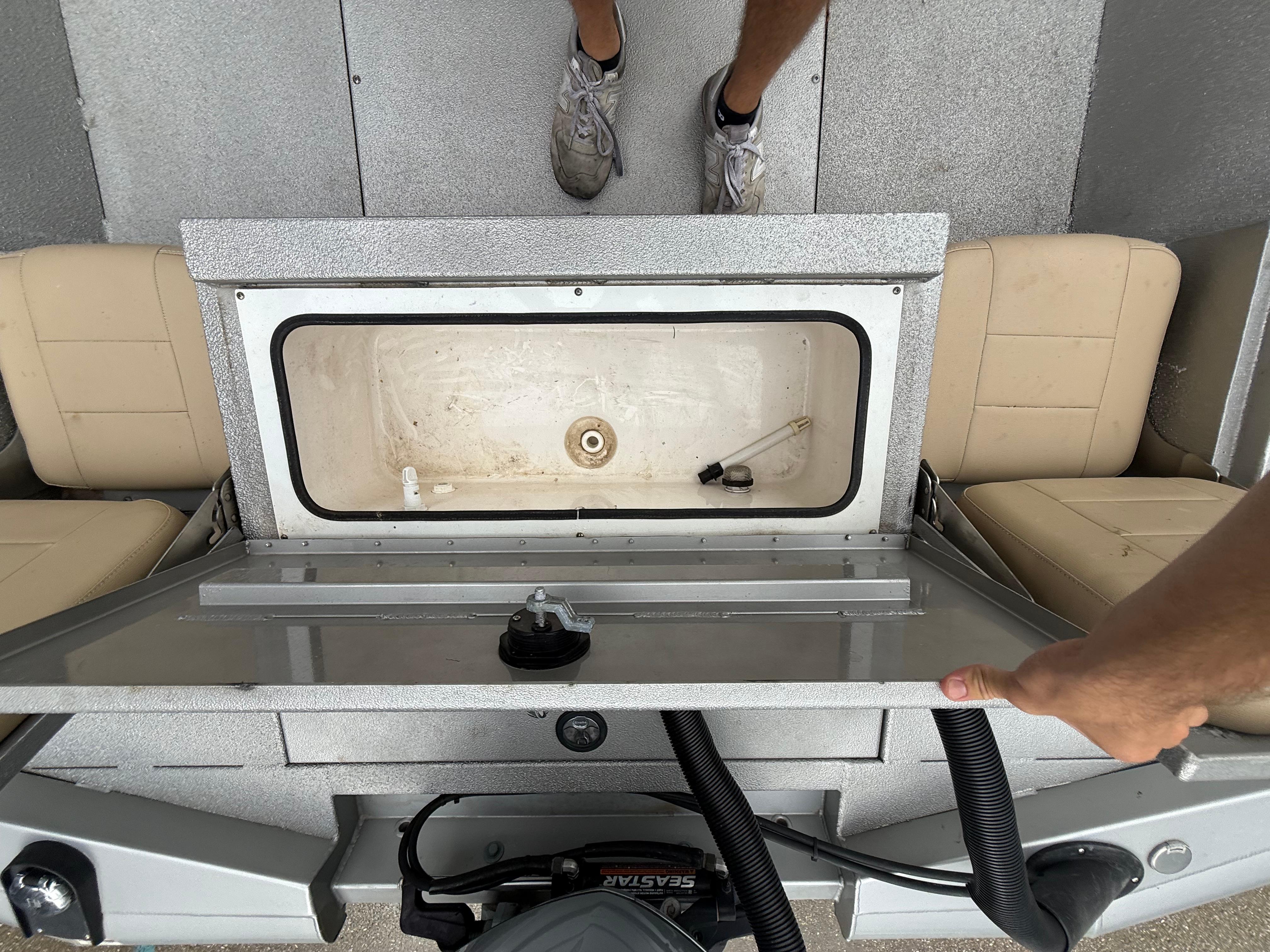2020 Avid 23 FS Platinum boat interior with open storage compartment.