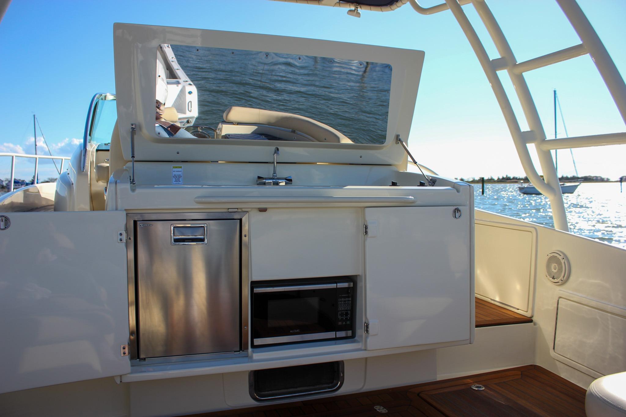 2017 Chris-Craft Launch 38 boat interior with kitchenette, featuring stainless steel appliances.