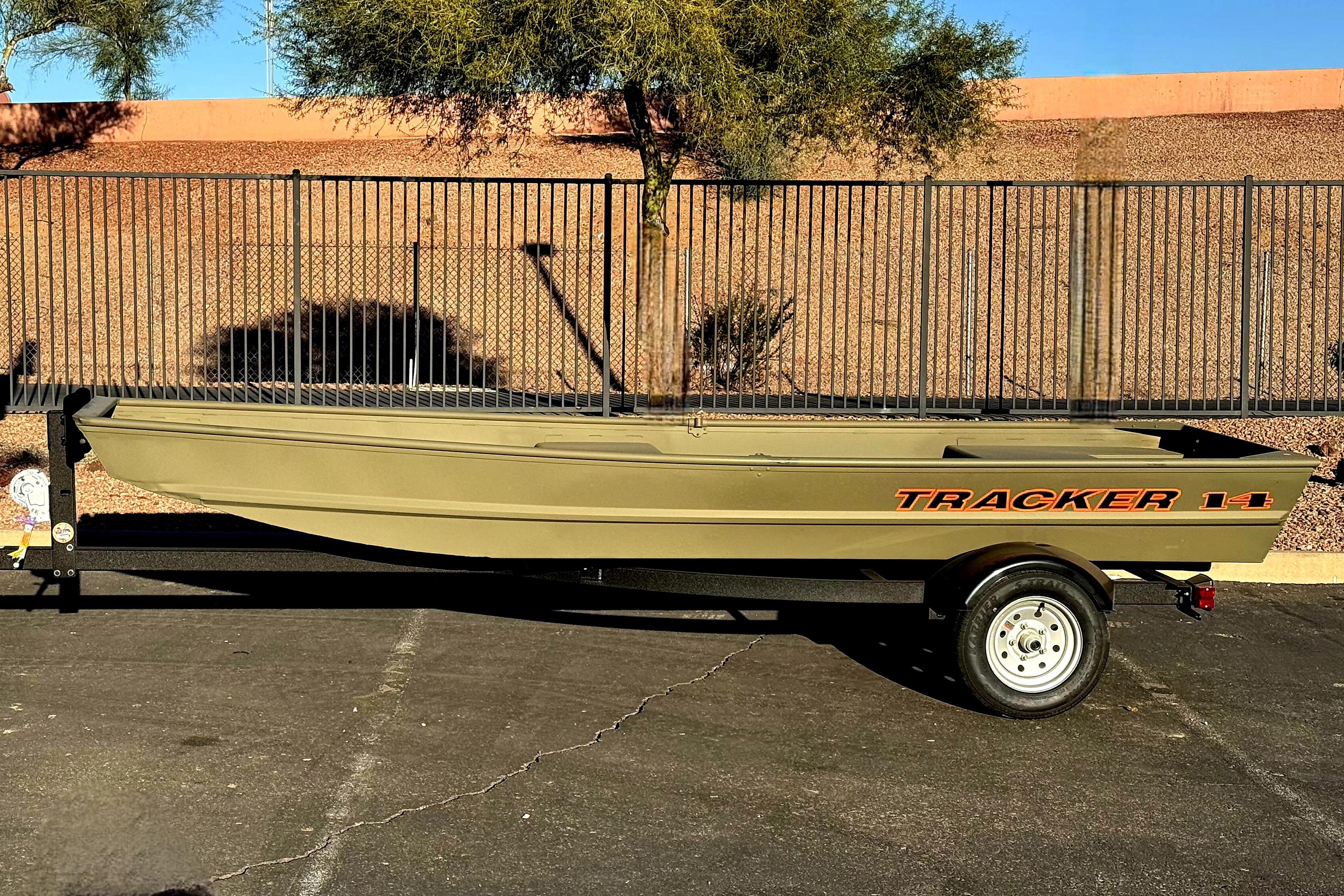 2026 Tracker Grizzly 14 Jon boat on trailer, parked outdoors.