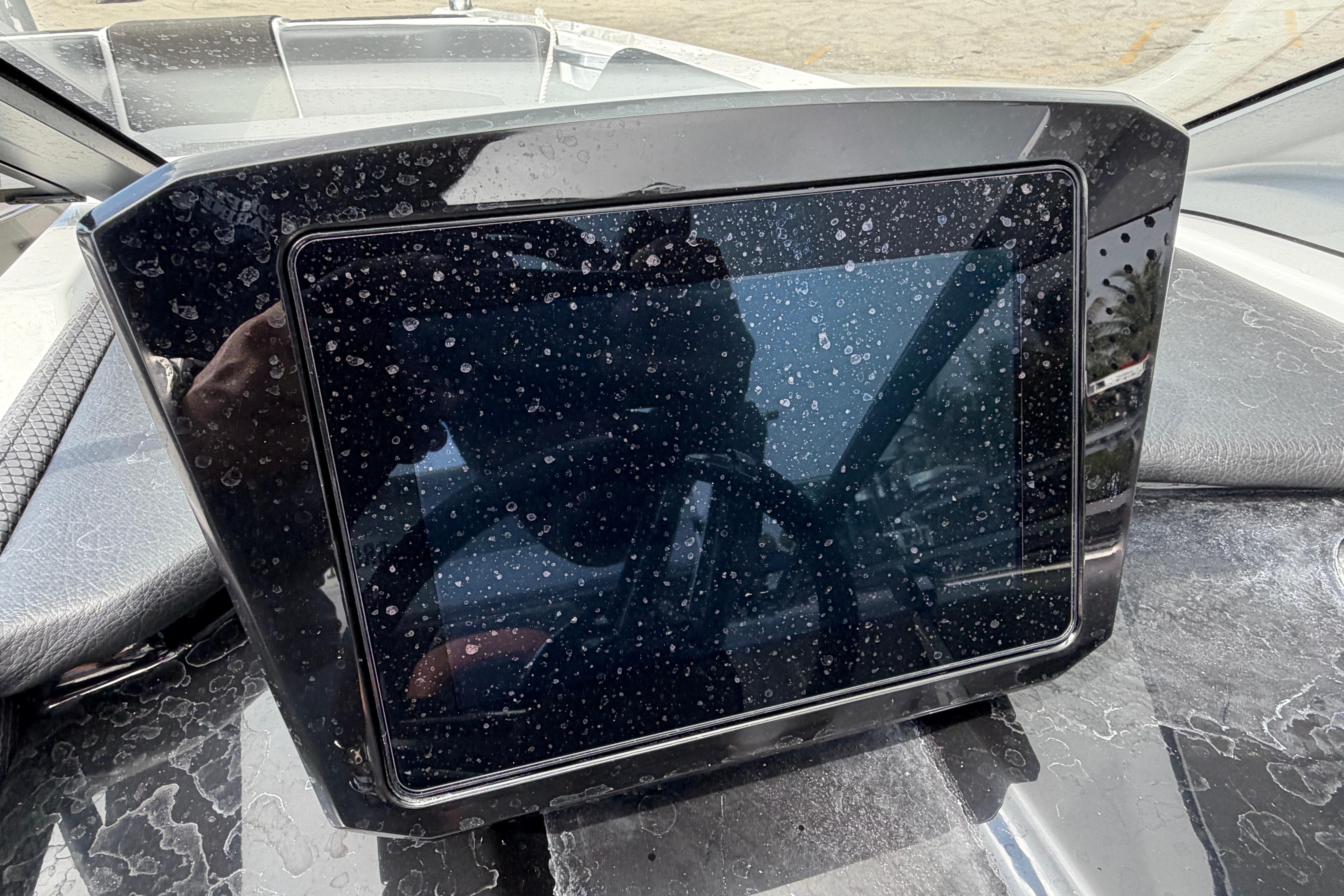 Dashboard of 2026 Scarab 235 LX boat with water droplets on display screen.