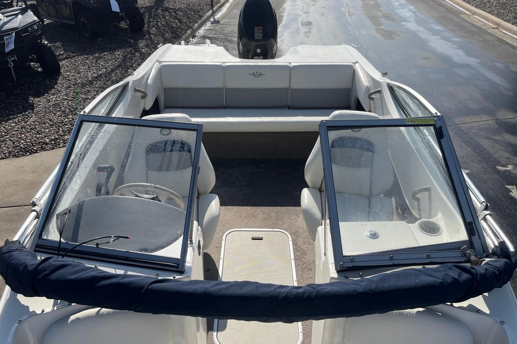 2013 Stingray 191 RX boat interior with seating and windshield, parked on a wet surface.