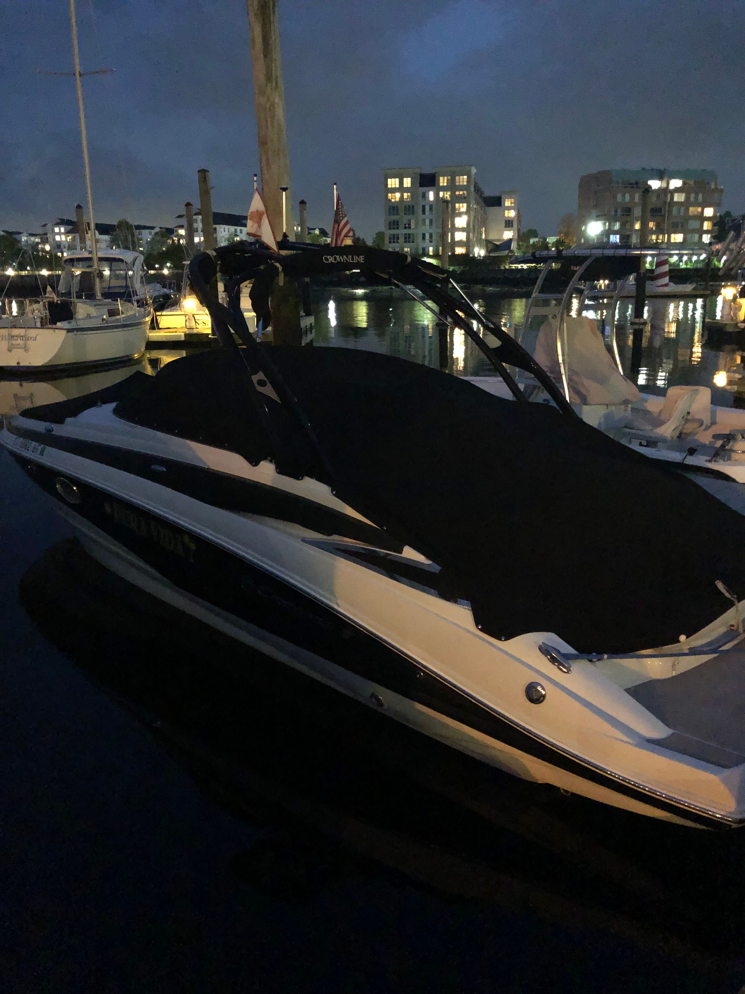 A 2013 Crownline E-4 Bowrider docked at night in a marina.