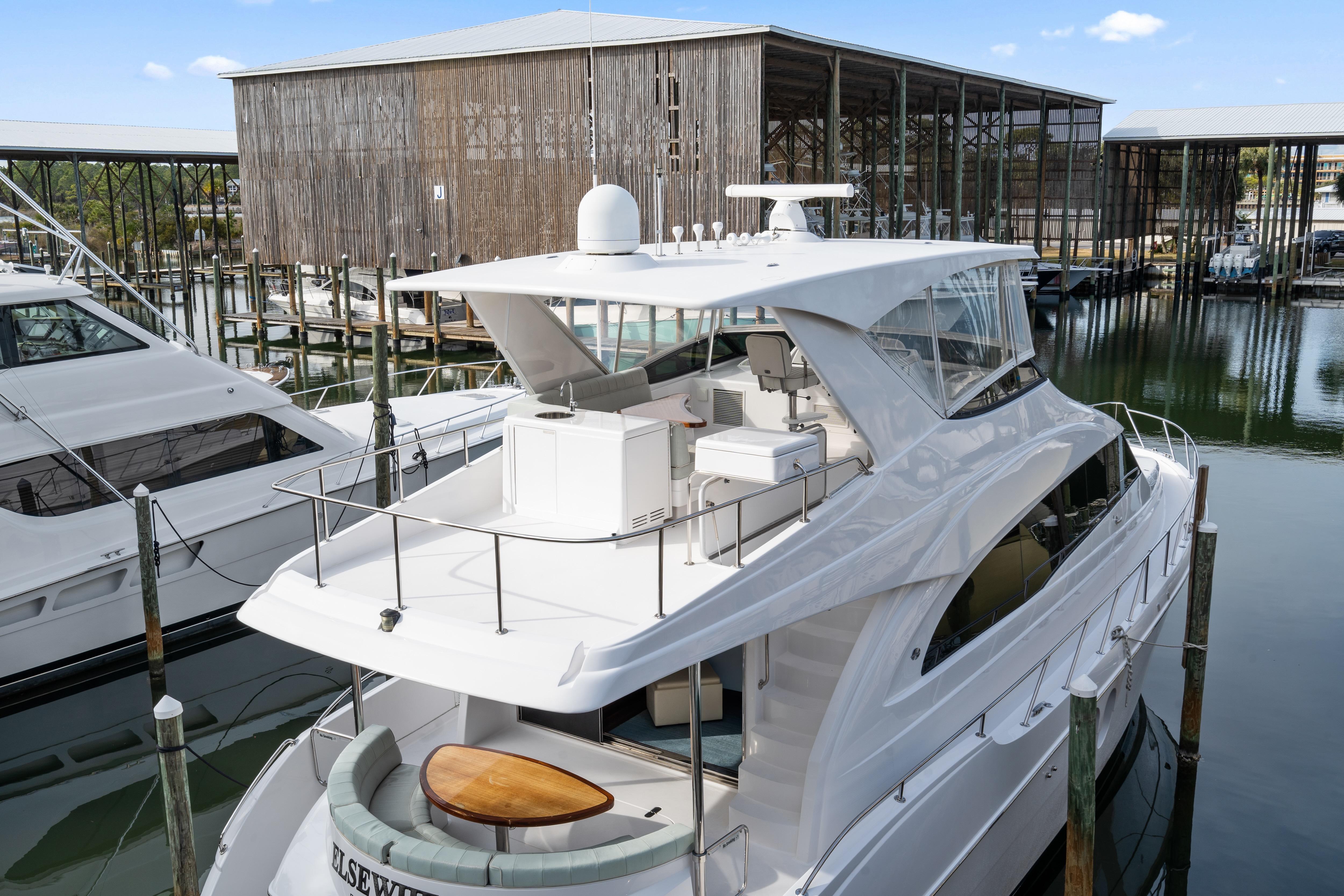 2013 Hatteras 60 Motor Yacht docked at marina, showcasing sleek design and spacious deck.