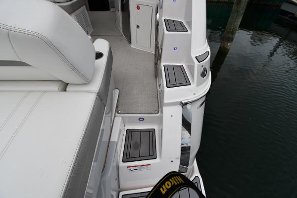 2021 Regal 35 Sport Coupe boat interior with white seating and steps near water.