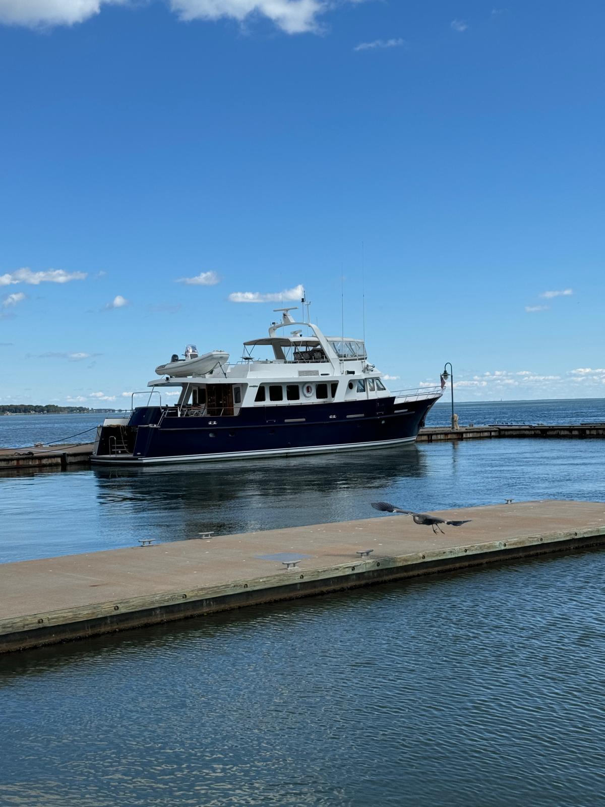 A 1987 Jongert 78 Motor Yacht docked in calm waters under a clear blue sky.