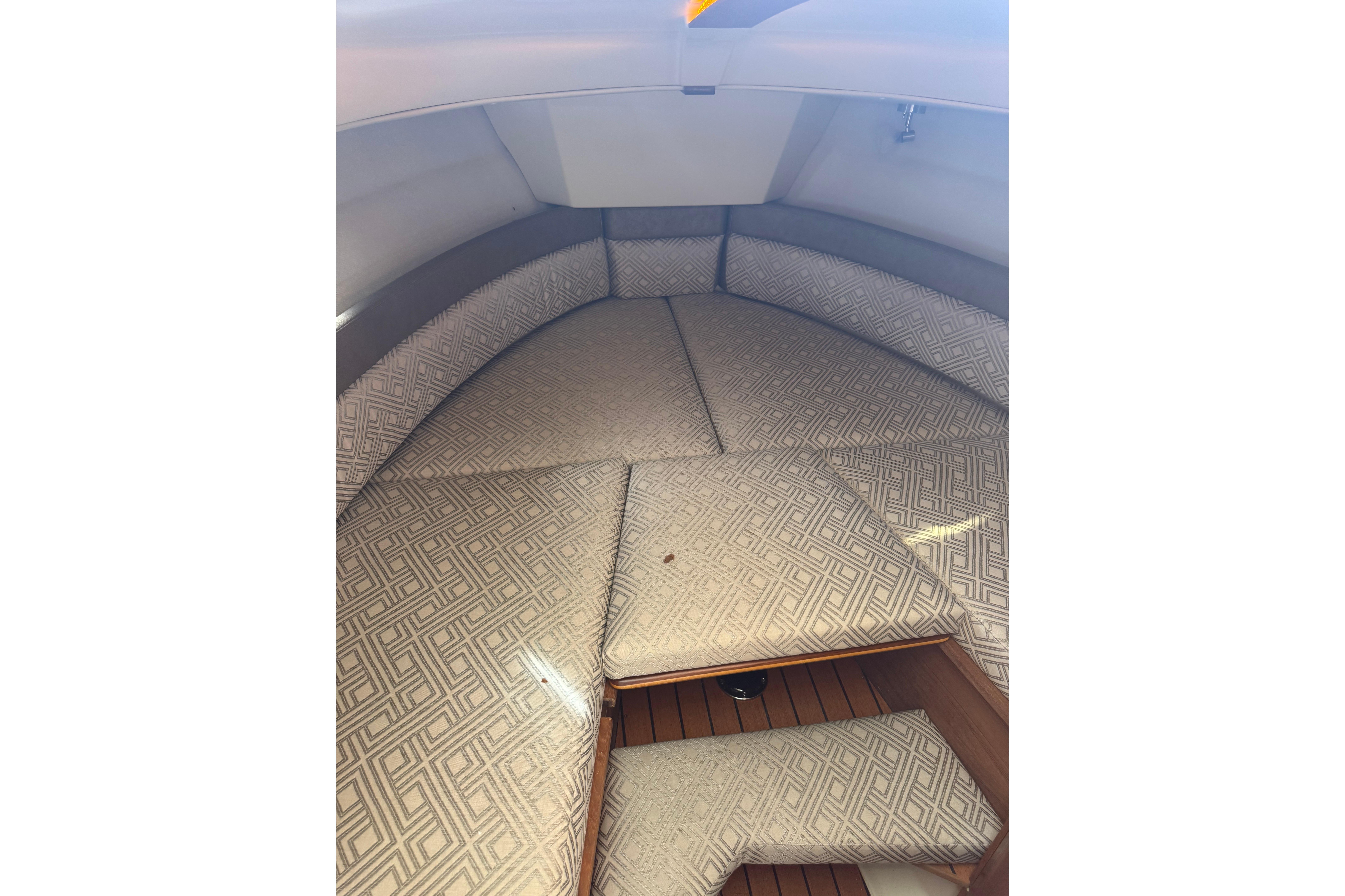 2021 Ranger Tugs R-25 cabin interior with patterned cushions and wooden flooring.