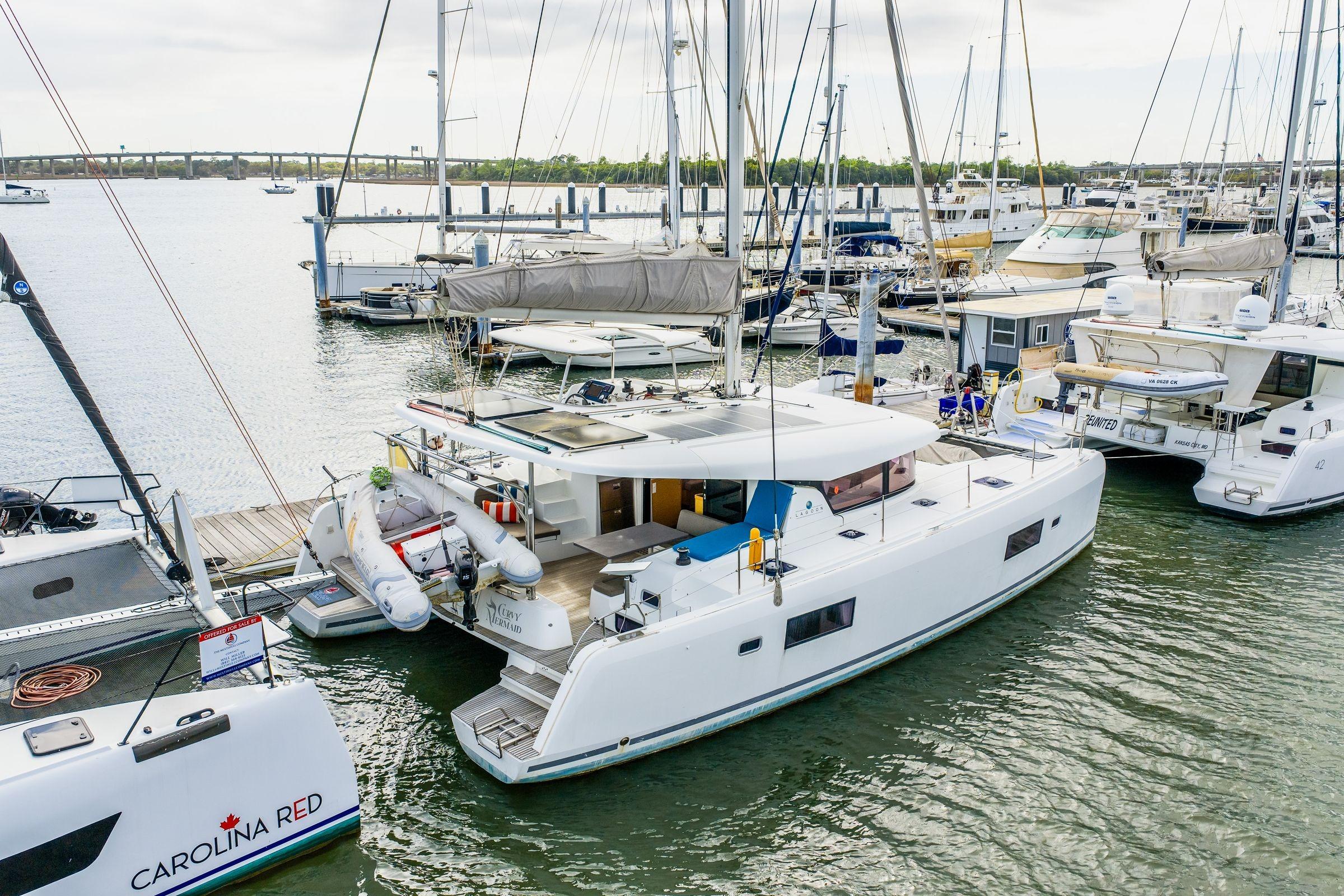 2017 Lagoon 42 catamaran docked in a marina, surrounded by other boats.
