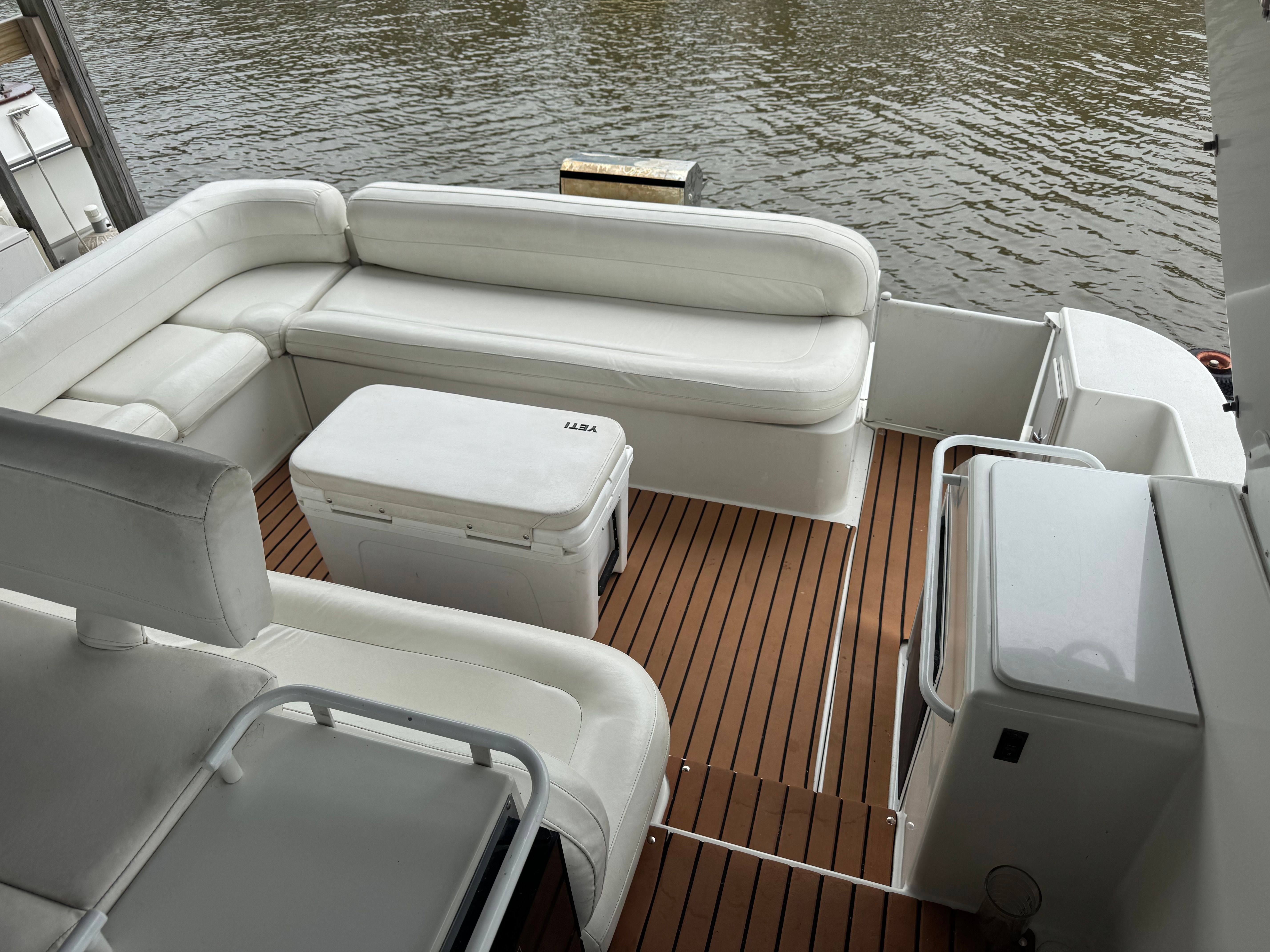 The image shows the deck of a 1995 Trojan 390x boat with white seating.