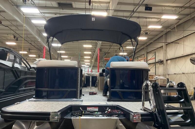 2026 Bennington 22 SSRSE pontoon boat in a warehouse, rear view with canopy.