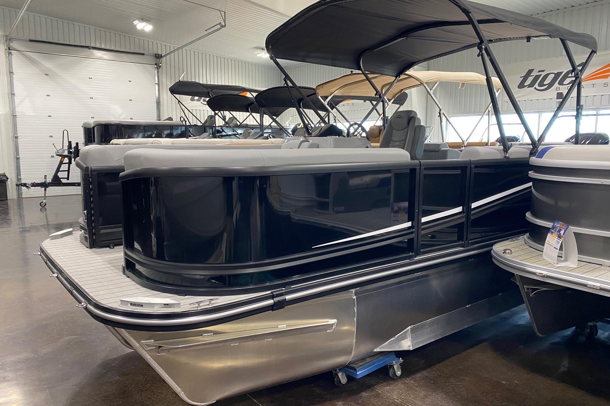 2026 SunCatcher Fusion 324SS pontoon boat in showroom, featuring sleek black design and spacious seating.