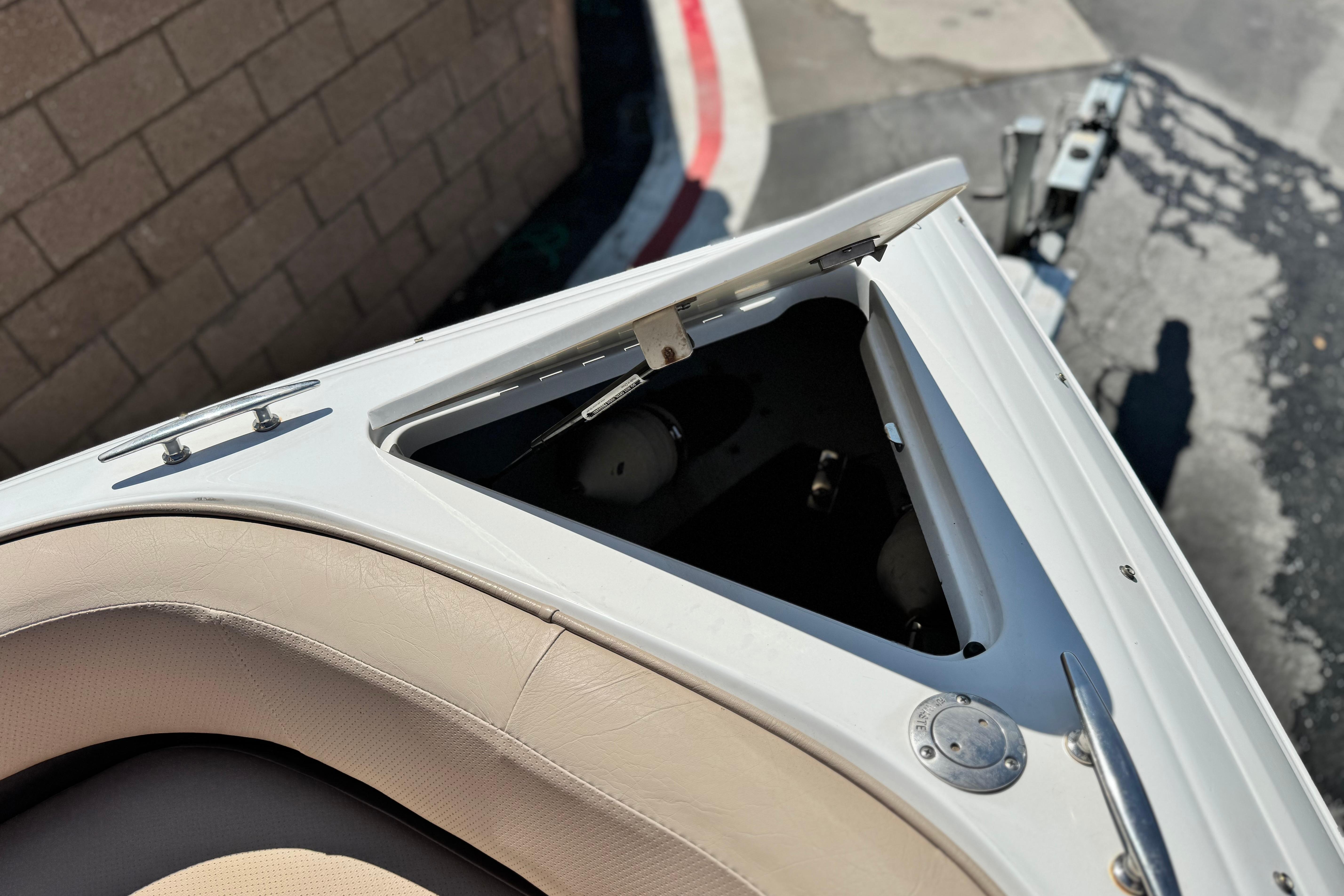2008 Cobalt 262 boat bow with open storage compartment, beige seating, and metal fittings.