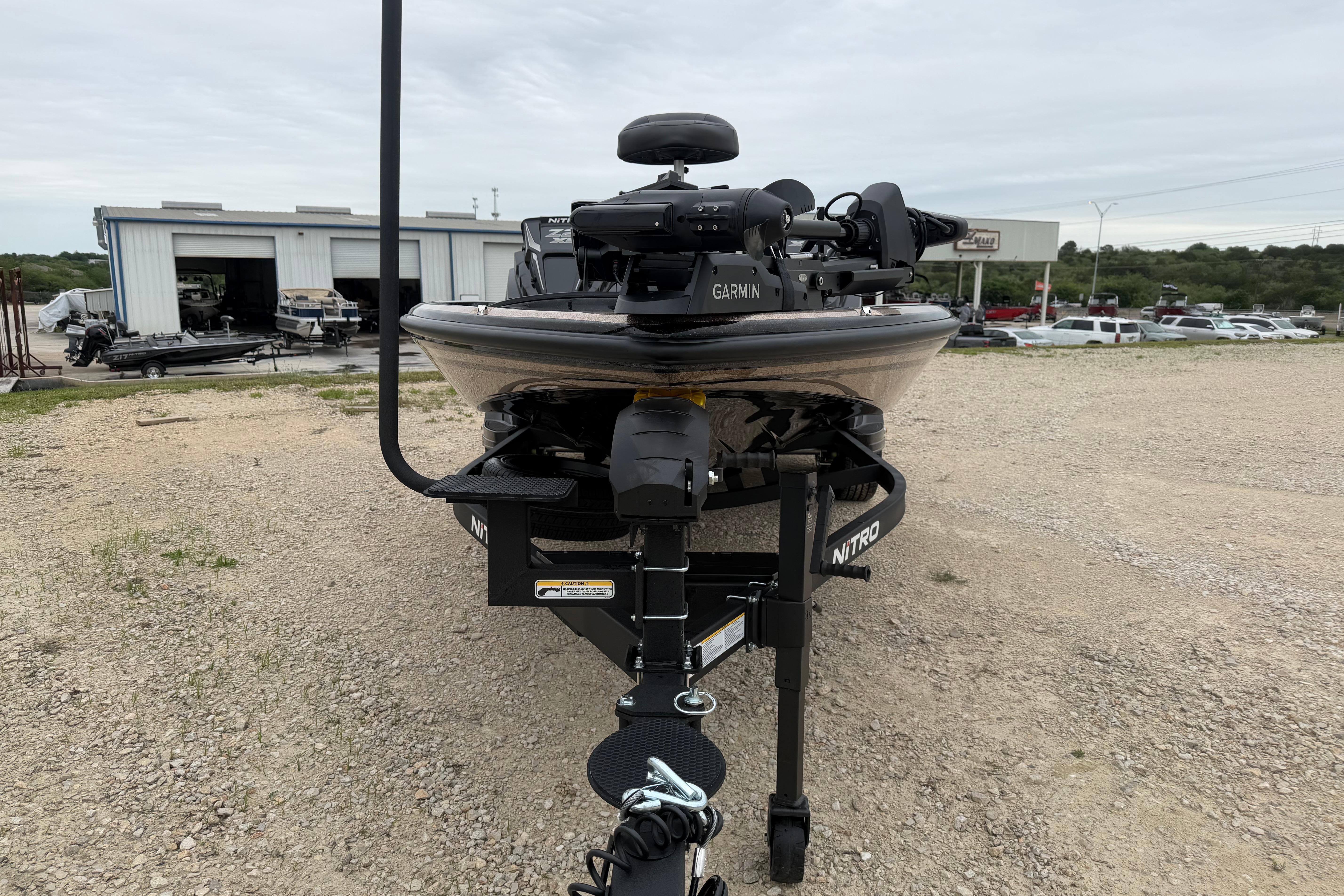 2026 Nitro Z21 XL Pro boat with Garmin equipment, parked outdoors near a workshop.