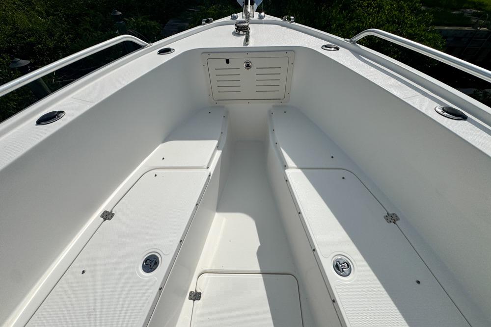 2018 Mako 284 Center Console boat interior with white seating and storage compartments.