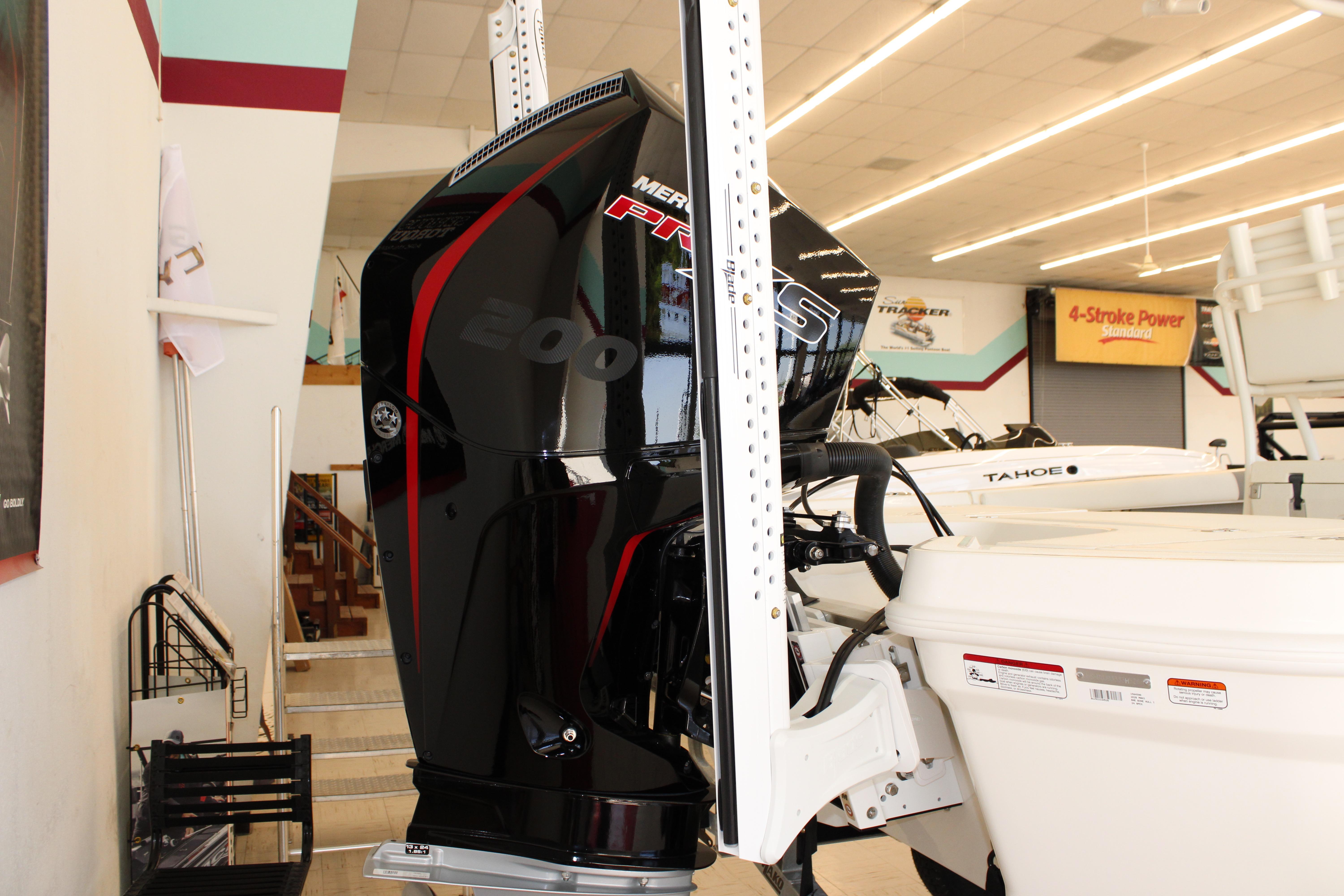 2026 Mako 24 APEX boat with Mercury 200 outboard engine in showroom.